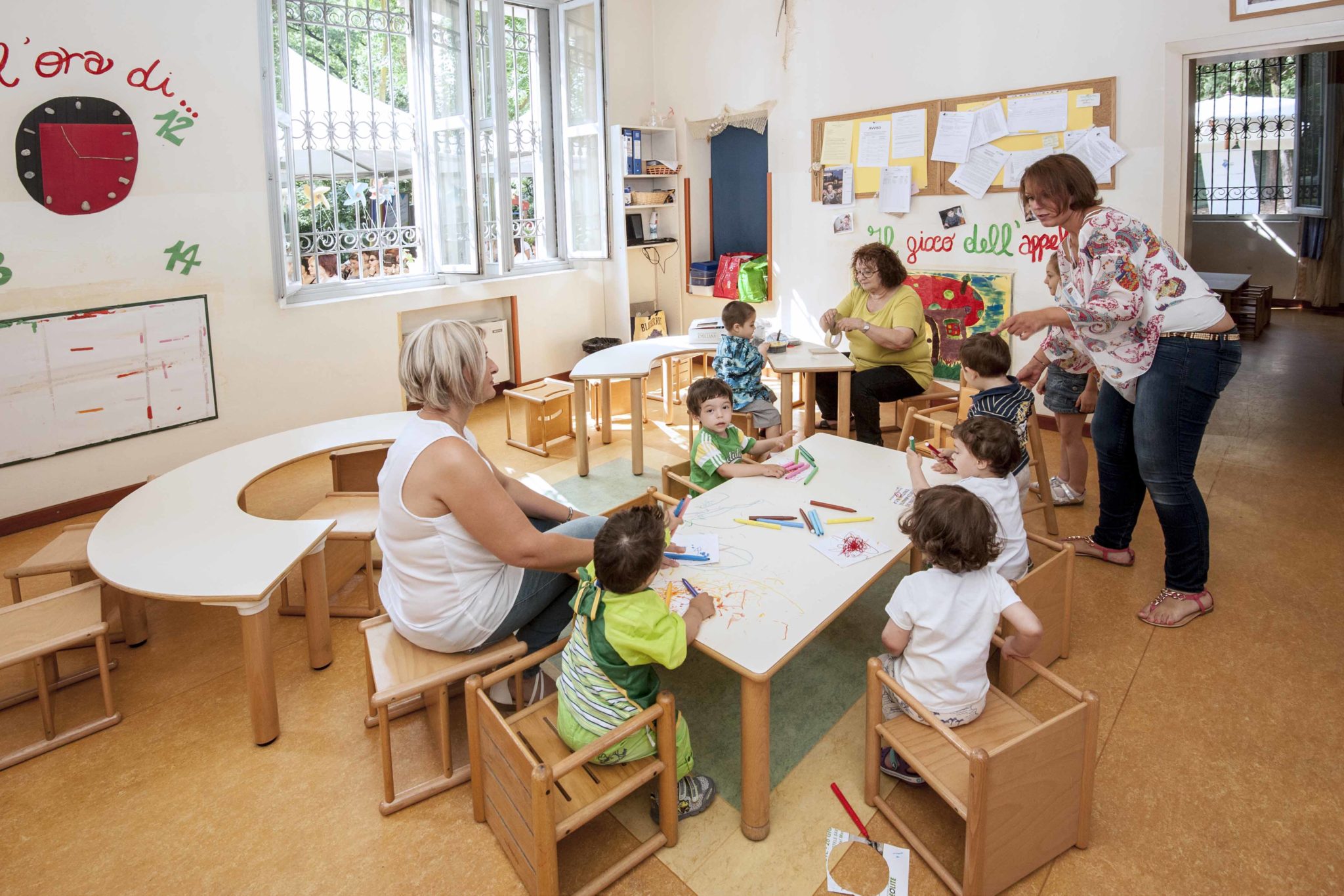 Un'immagine che ritrae mobilia, tavolo, sedia, classe e bambino.