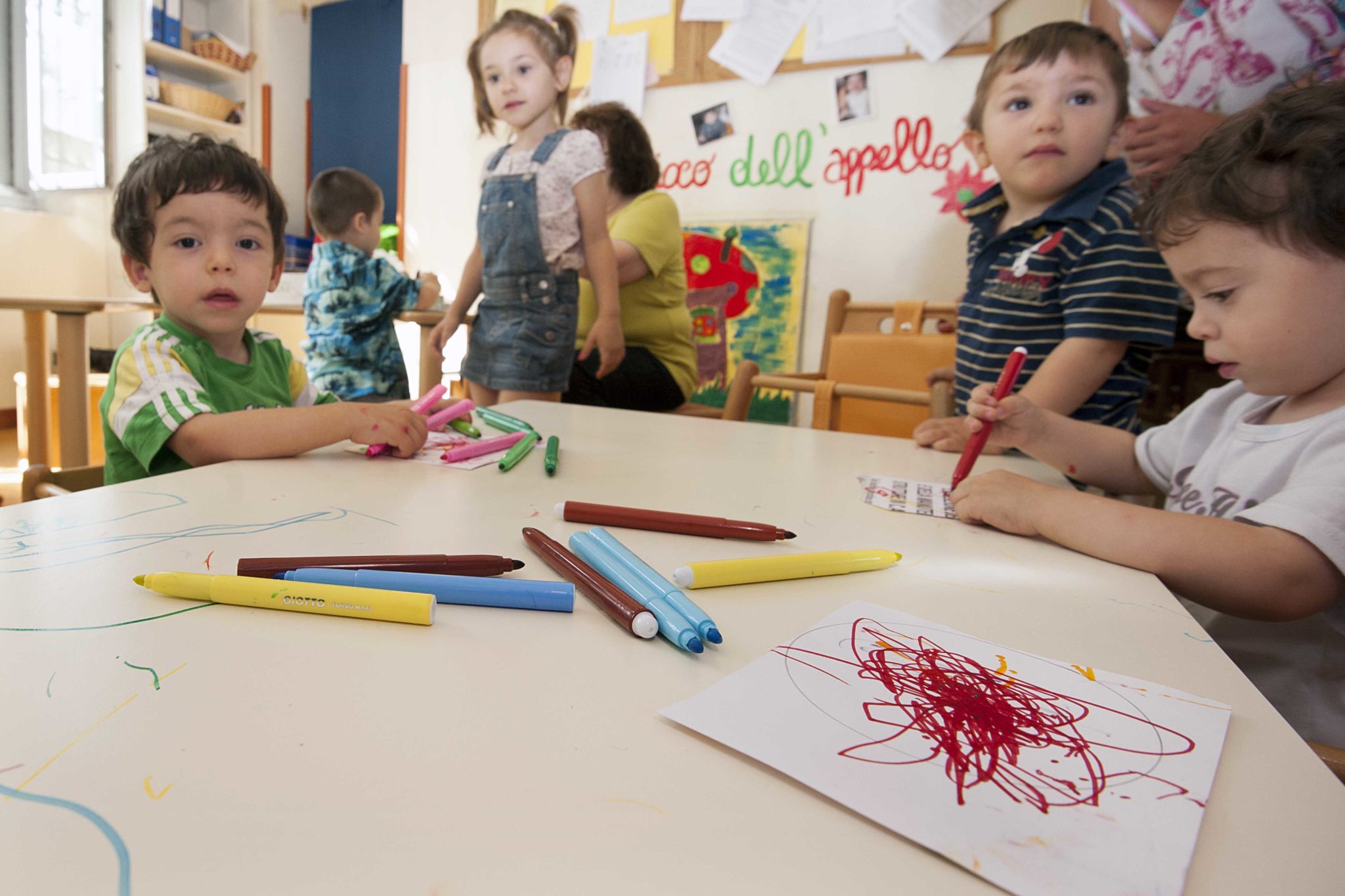 Un'immagine che ritrae bambino, dito, tavolo, arte infantile e mobilia.