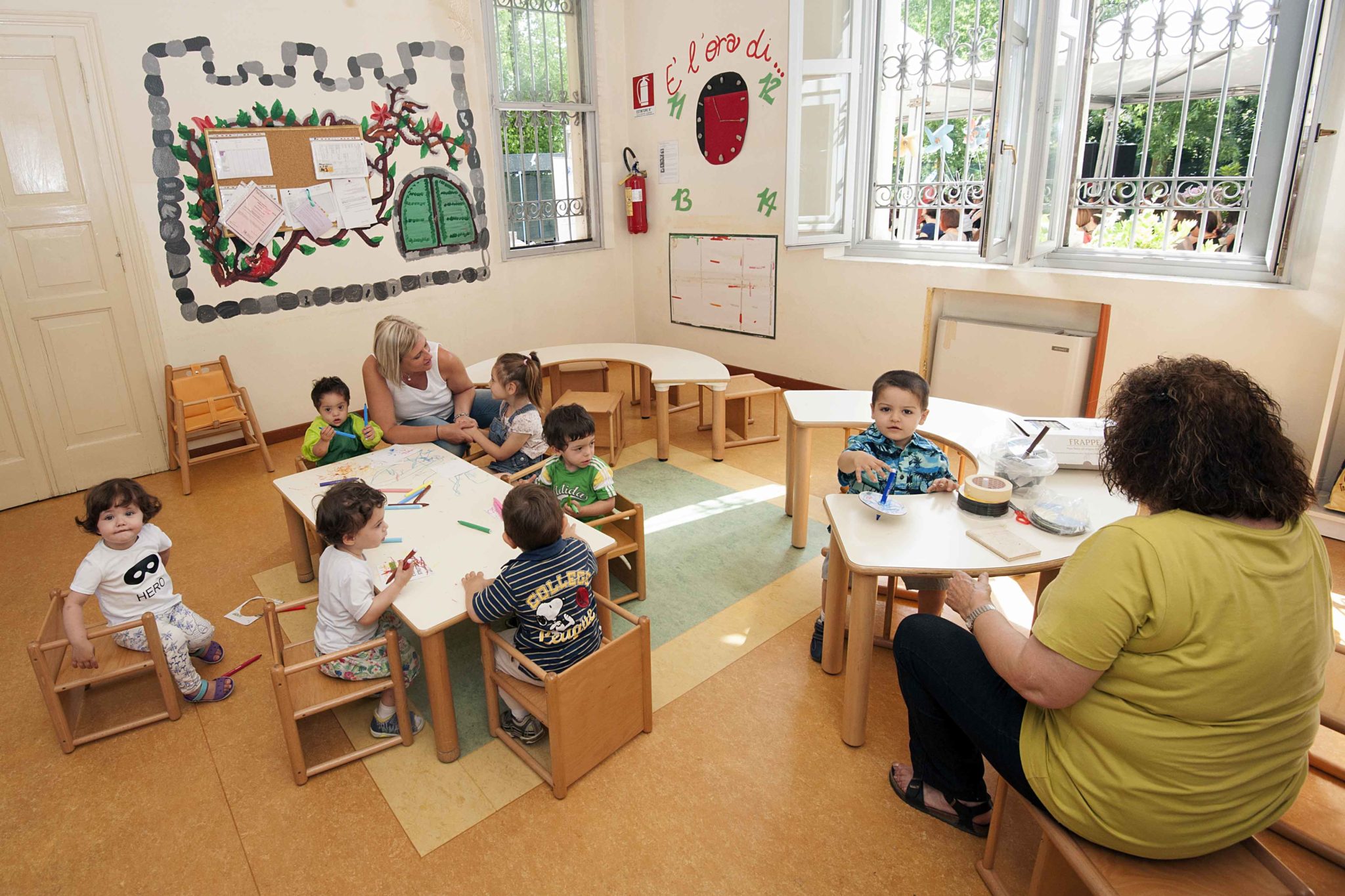 Un'immagine che ritrae mobilia, tavolo, classe, aula e bambino.