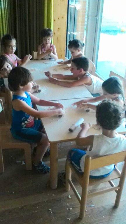 Un'immagine che ritrae testa, mobilia, maglietta, tavolo e bambino.
