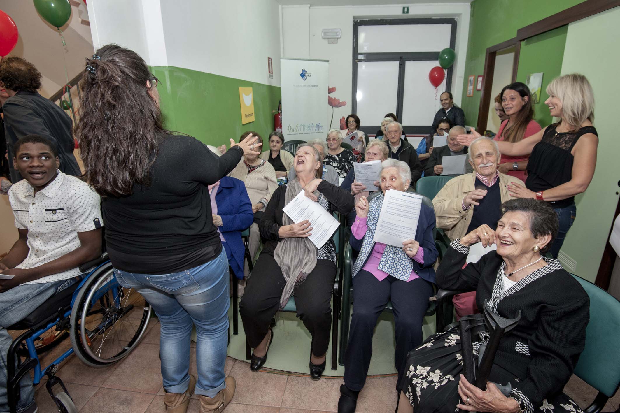 Un'immagine che ritrae sedia a rotelle, pantaloni, gruppo sociale, comunità e jeans.