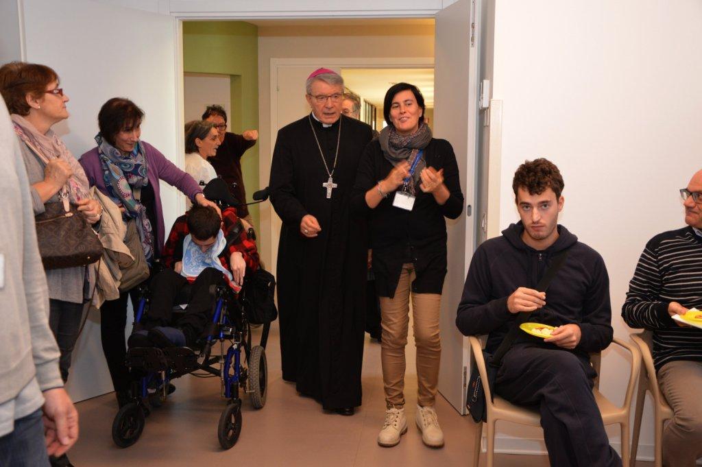 Un'immagine che ritrae capispalla, clero, sorriso, giacca e bagagli e borse.