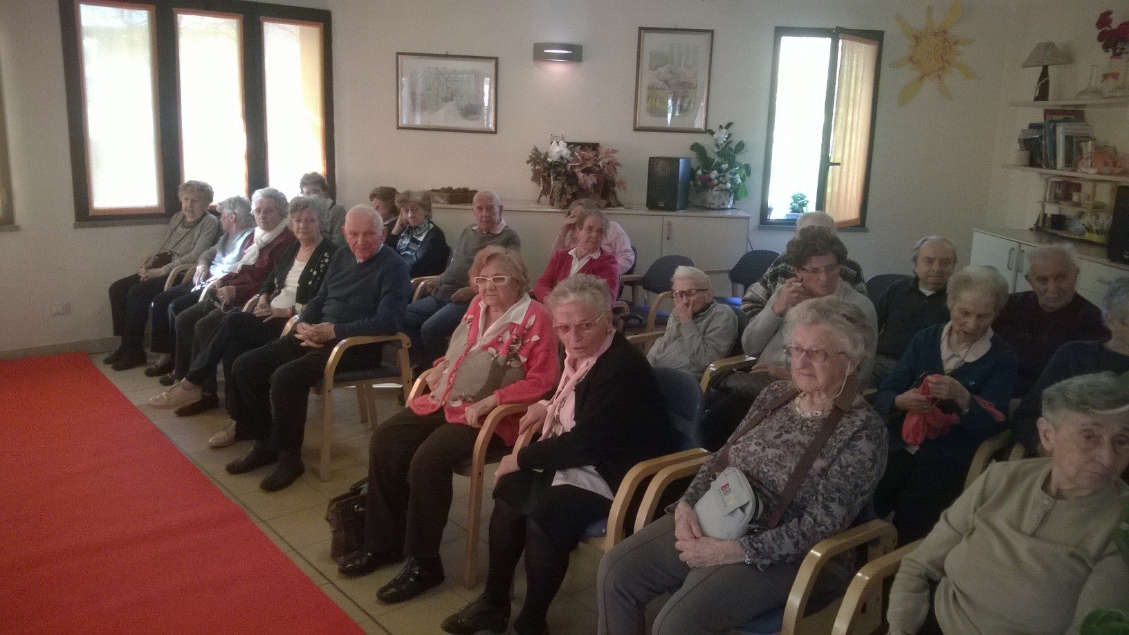 Un'immagine che ritrae comunità, sedia, sala, abito e casa di riposo.