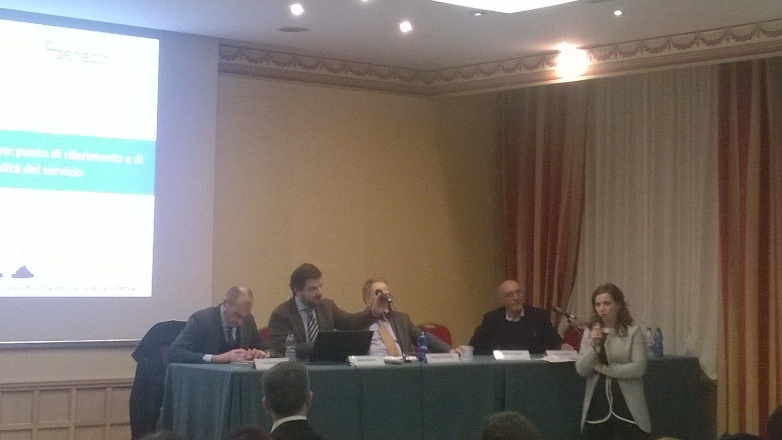 Un'immagine che ritrae mobilia, dispositivo elettronico, evento, tavolo e presentazione.