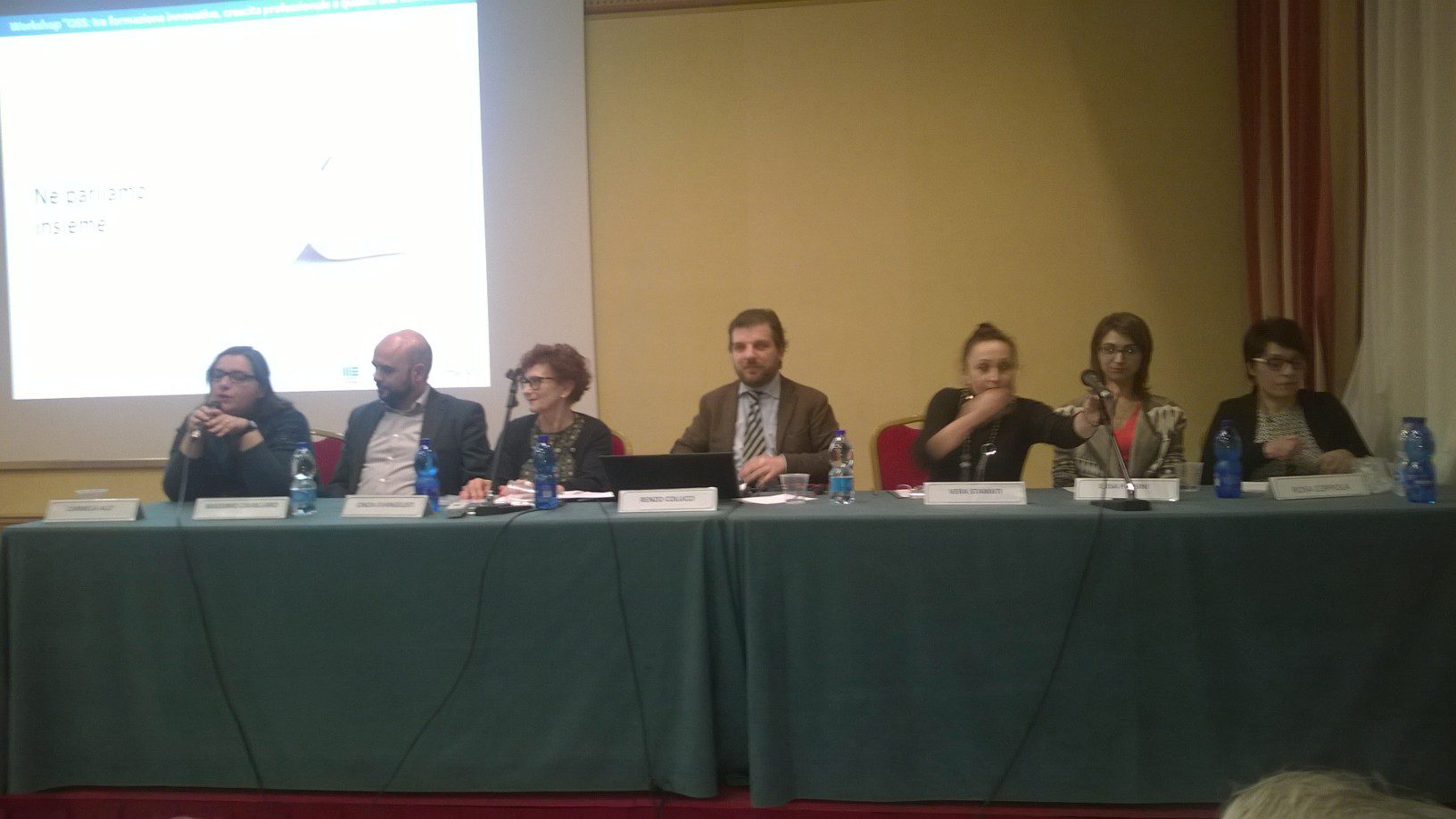 Un'immagine che ritrae mobilia, tavolo, evento, dispositivo elettronico e abito.