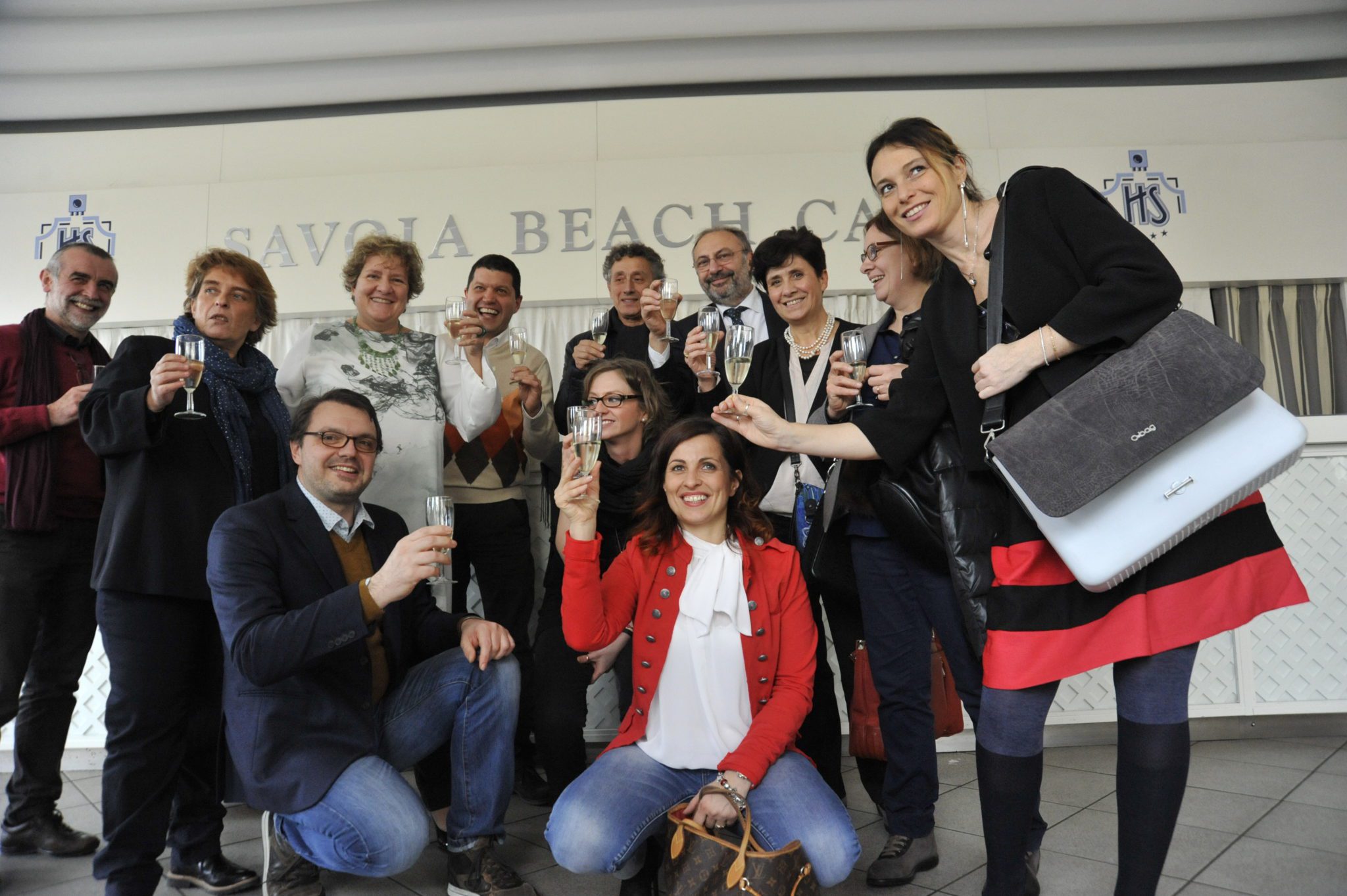 Un'immagine che ritrae sorriso, pantaloni, jeans, gruppo sociale e bagagli e borse.