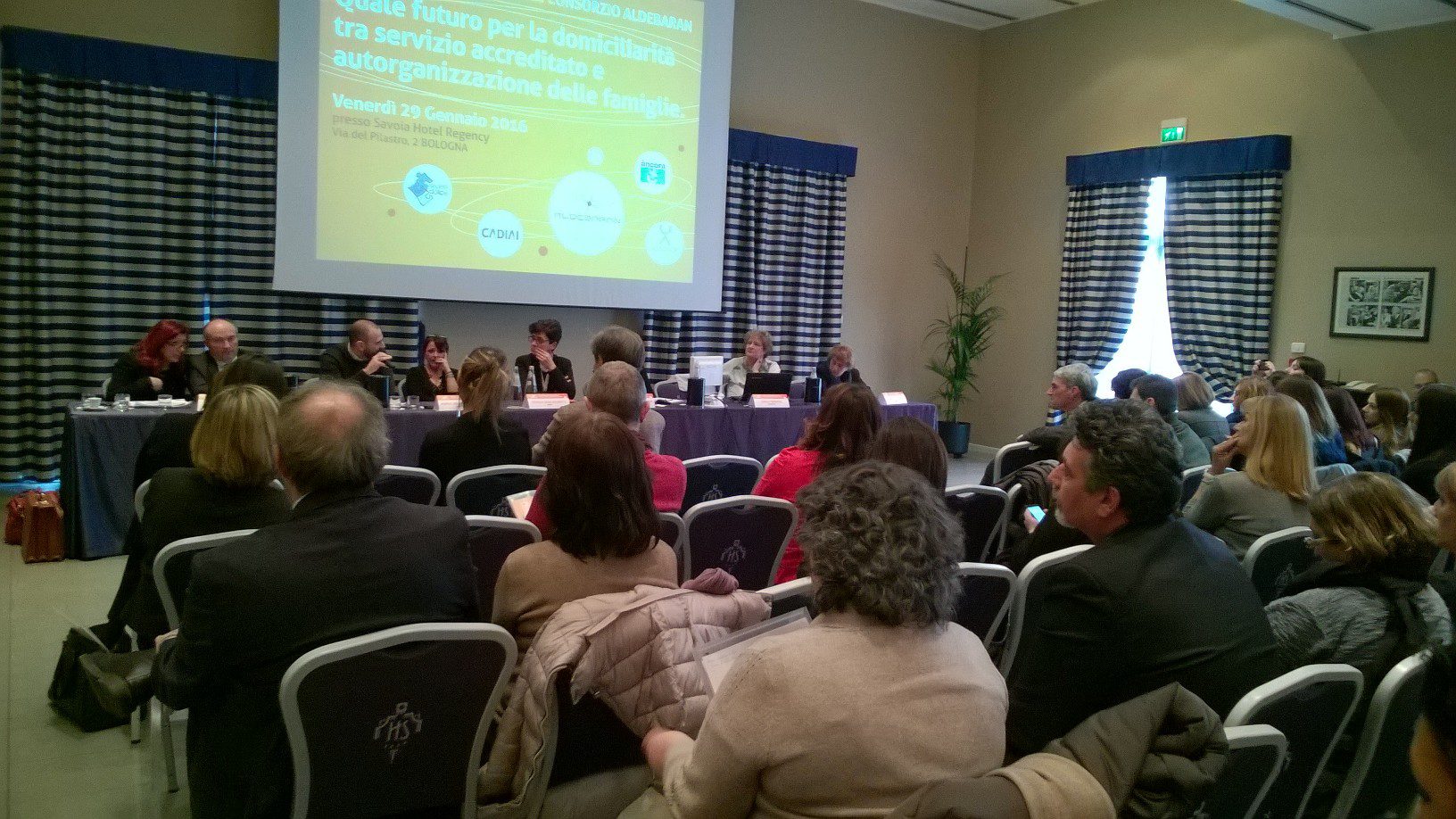 Un'immagine che ritrae mobilia, sedia, capispalla, presentazione e evento.