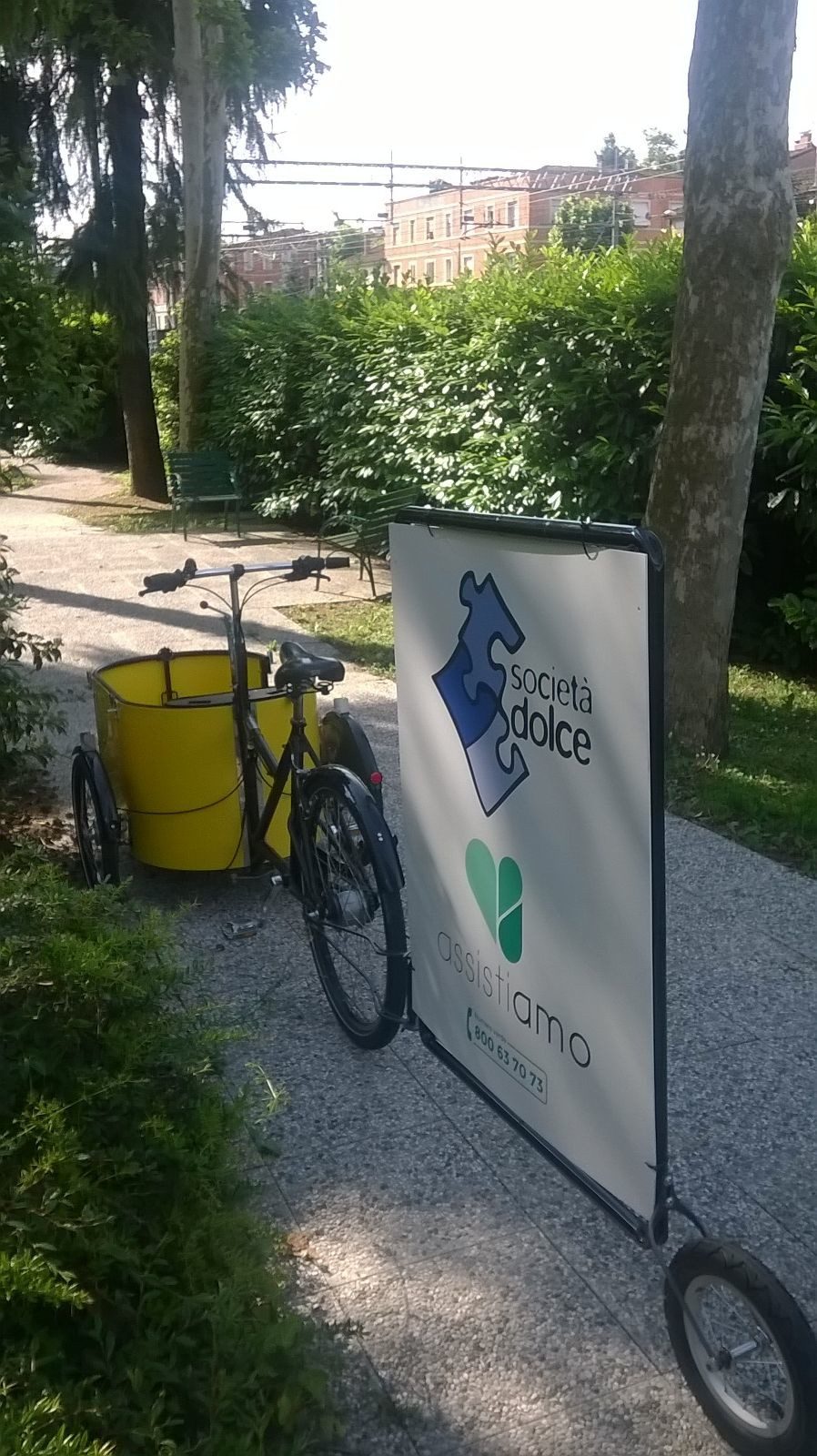 Un'immagine che ritrae pubblicità, bicicletta, ruota di bicicletta, bandiera e parlato.