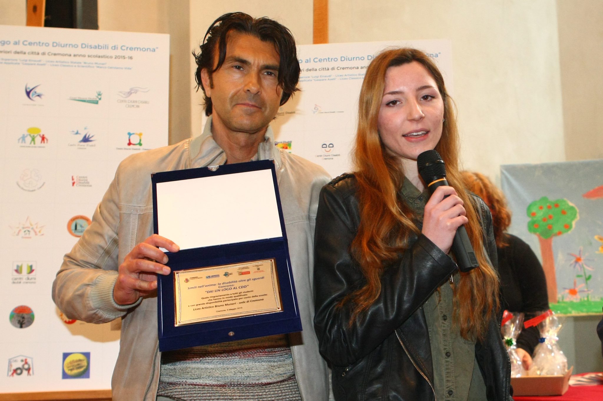 Un'immagine che ritrae sorriso, design di moda, cerimonia di premiazione, premio e sciarpa.