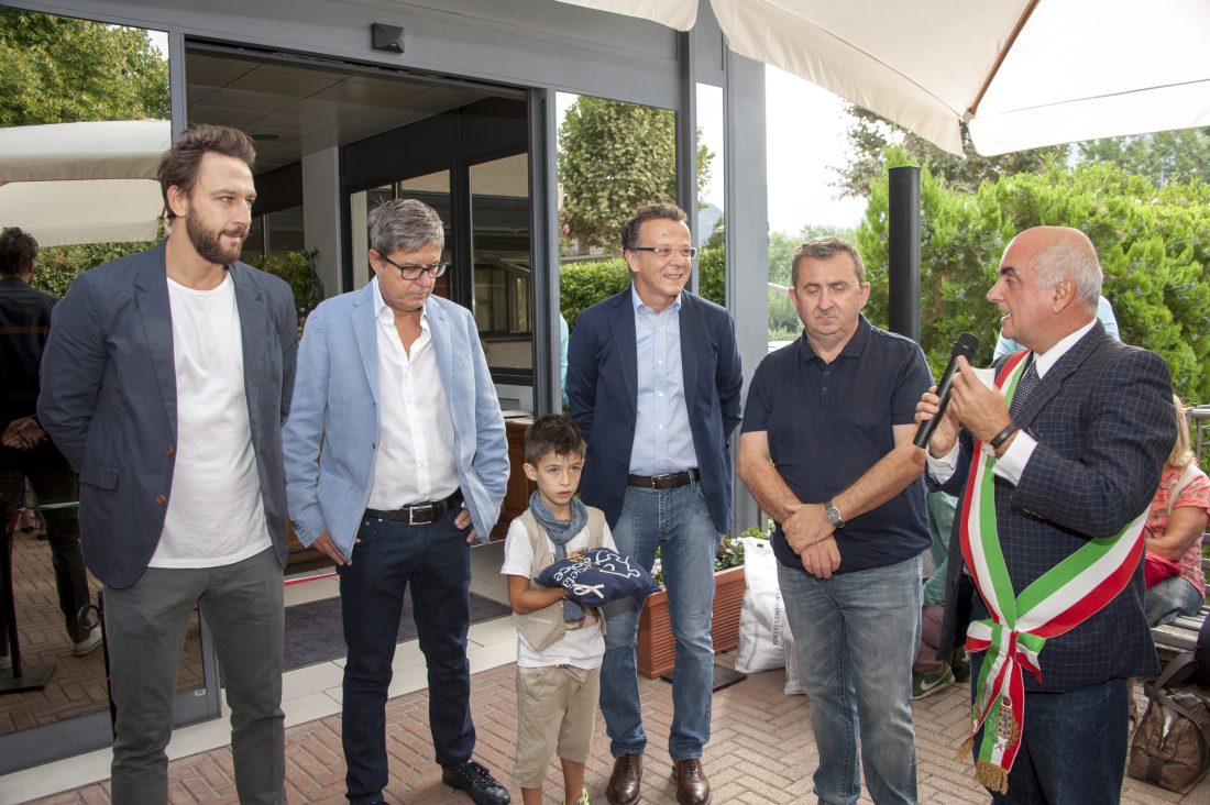 Un'immagine che ritrae vestiario, sorriso, pantaloni, gruppo sociale e jeans.