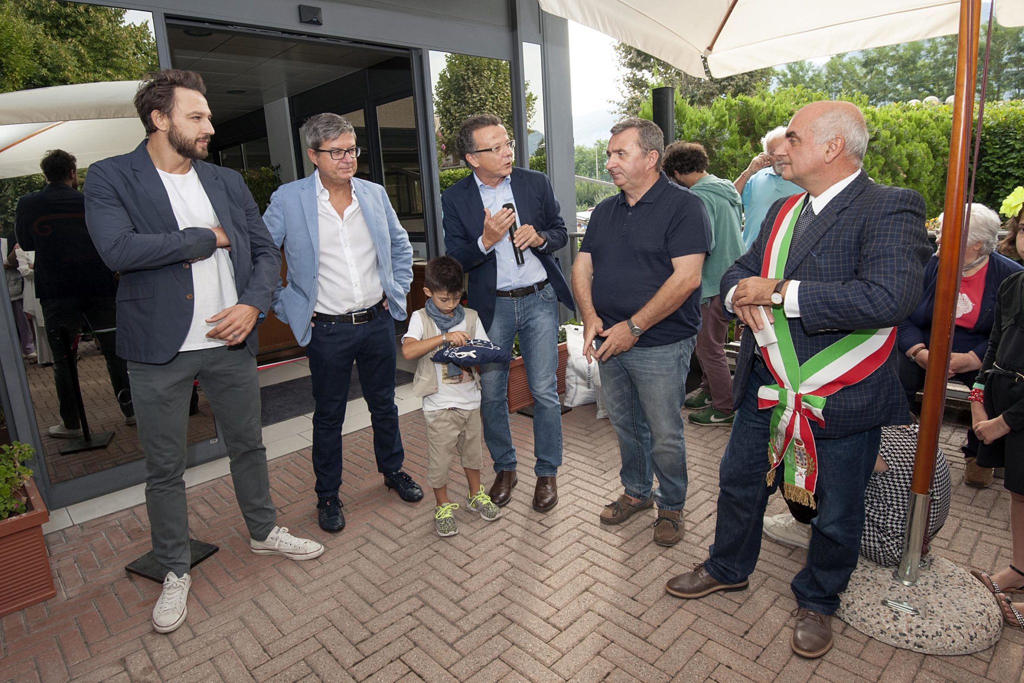Un'immagine che ritrae vestiario, pantaloni, capispalla, sorriso e gruppo sociale.