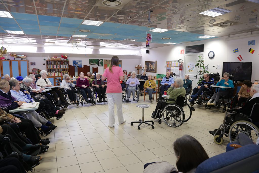 Un'immagine che ritrae sedia a rotelle, comunità, sedia, mobilia e seduta.