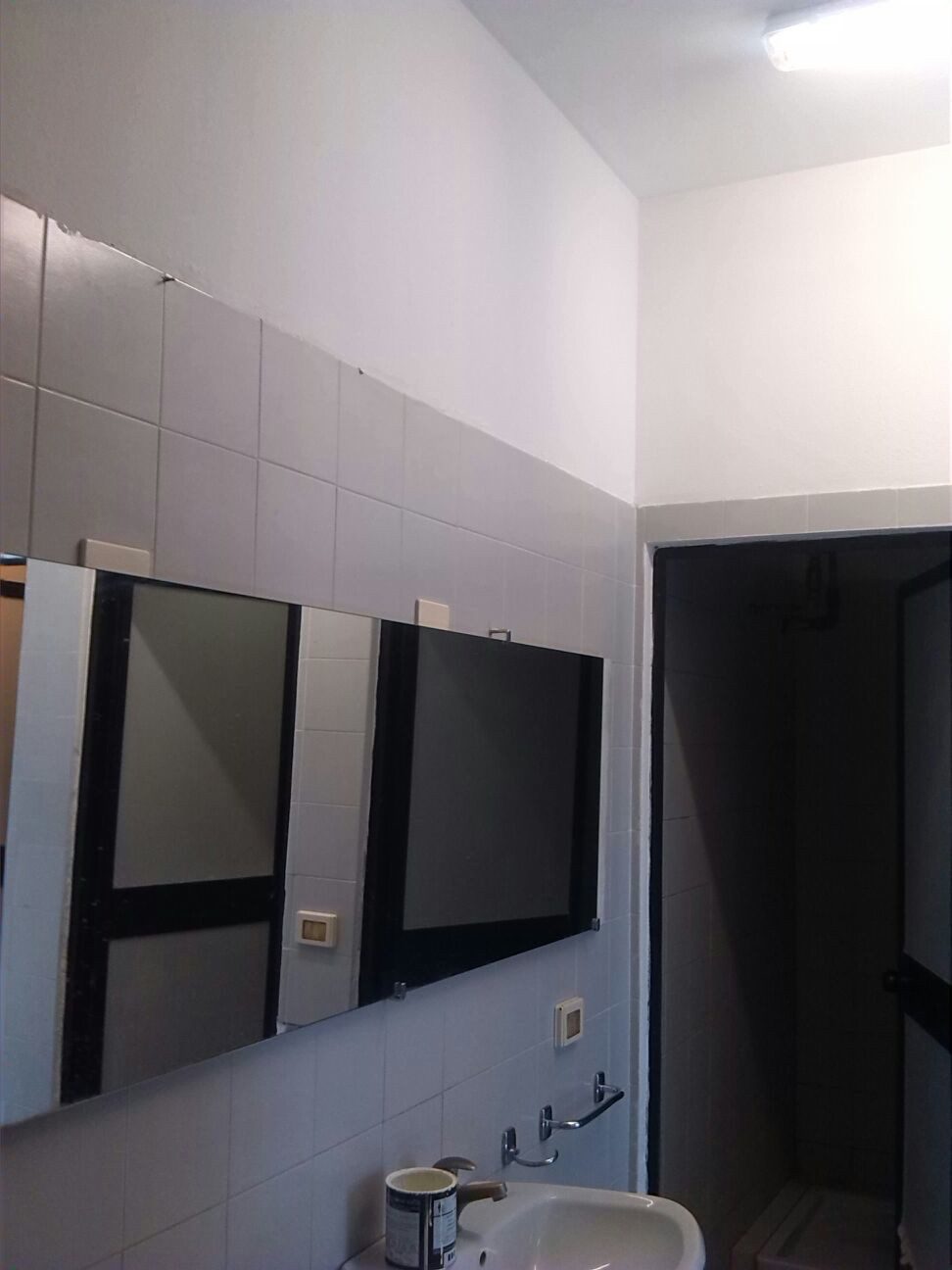 Un'immagine che ritrae soffitto, bicchiere, apparecchio di illuminazione, specchio e piastrella.