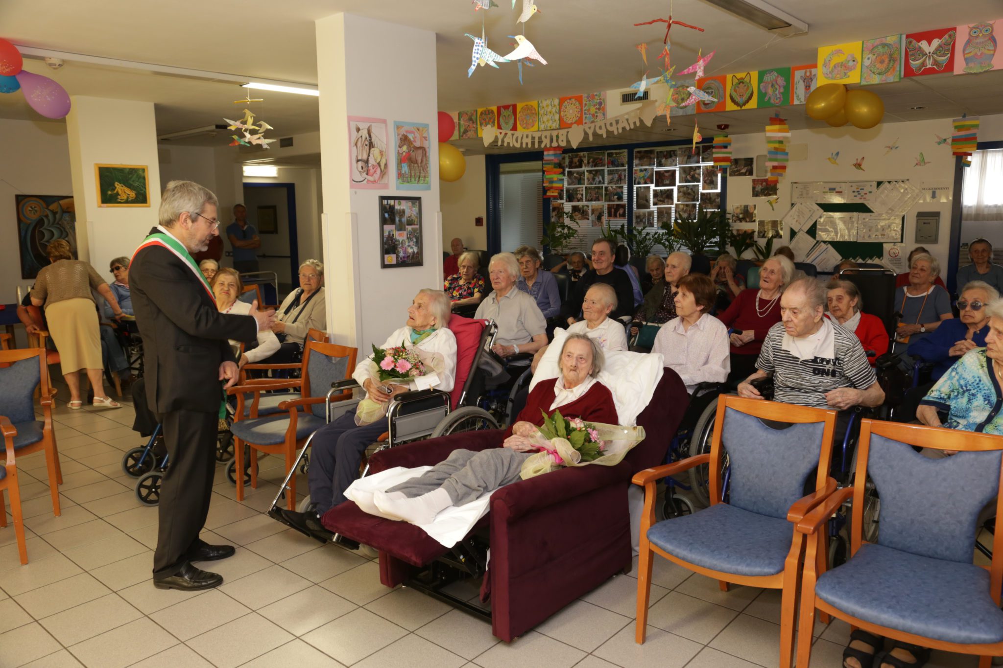 Un'immagine che ritrae comunità, mobilia, sedia, sedia a rotelle e condivisione.