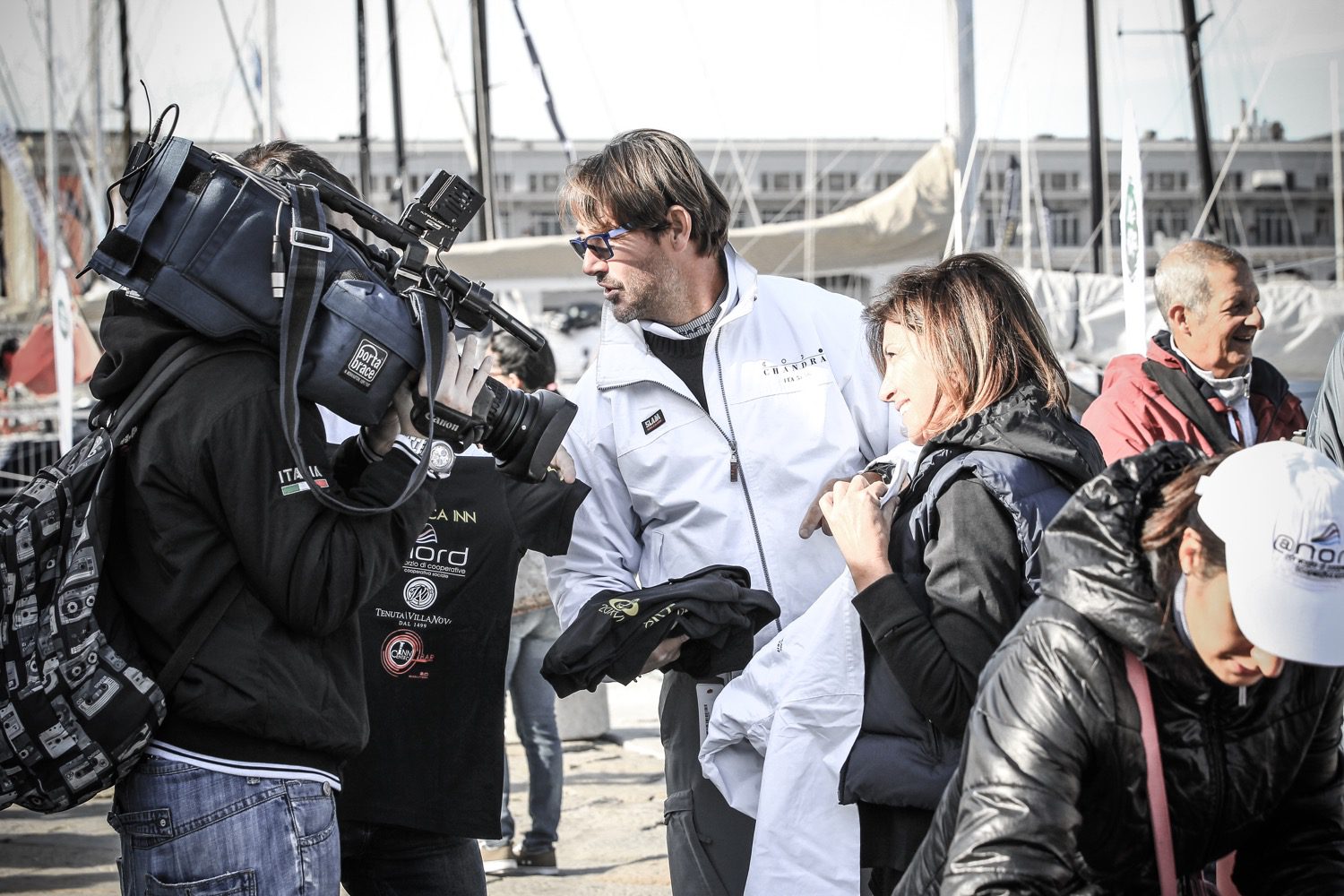 Un'immagine che ritrae fotocamere e ottiche, telecamera, videocamera, capispalla e giacca.