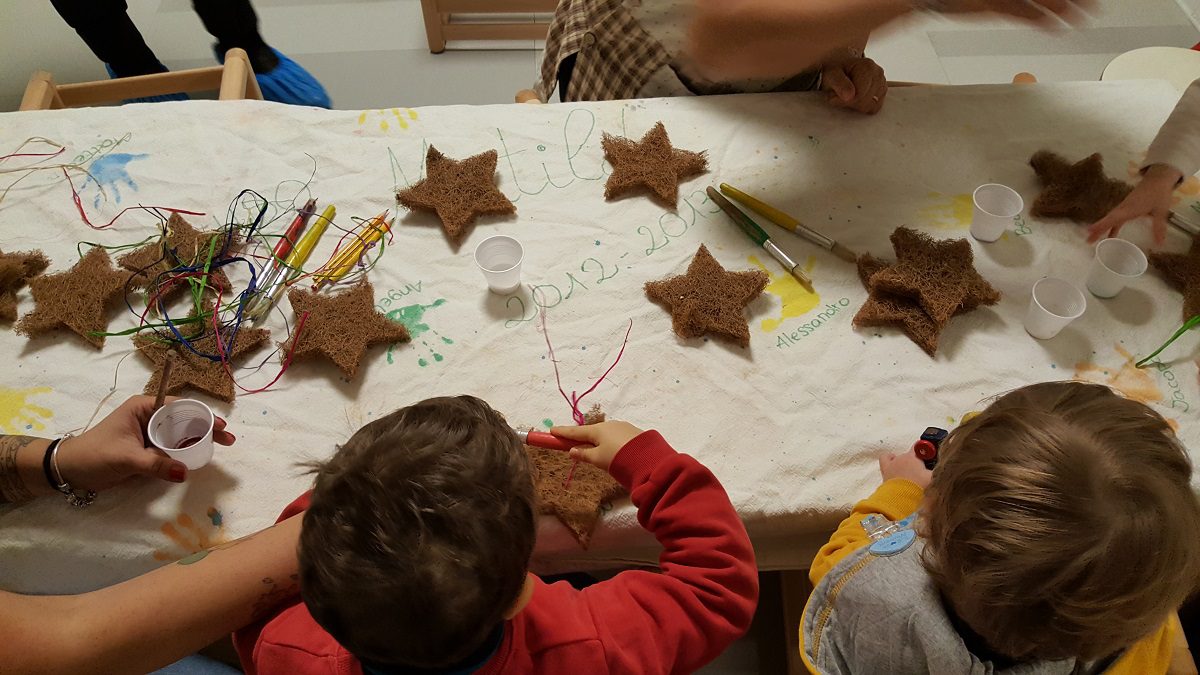 Un'immagine che ritrae bambino, bambino che fa i primi passi, carta, chiodo e giocare.