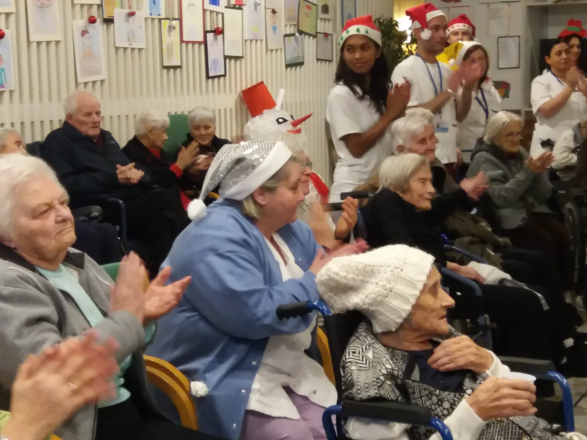 Un'immagine che ritrae comunità, sedia, casa di riposo, festa e nonno.