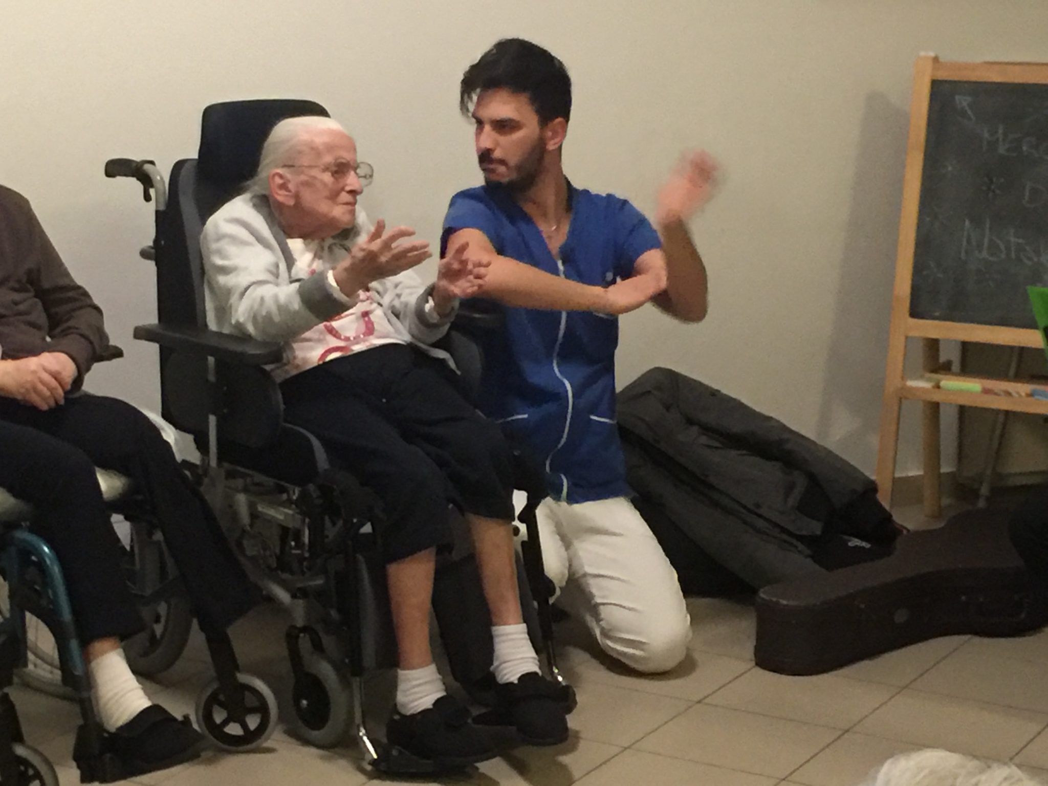 Un'immagine che ritrae sedia a rotelle, pantaloni, gamba, mobilia e seduta.