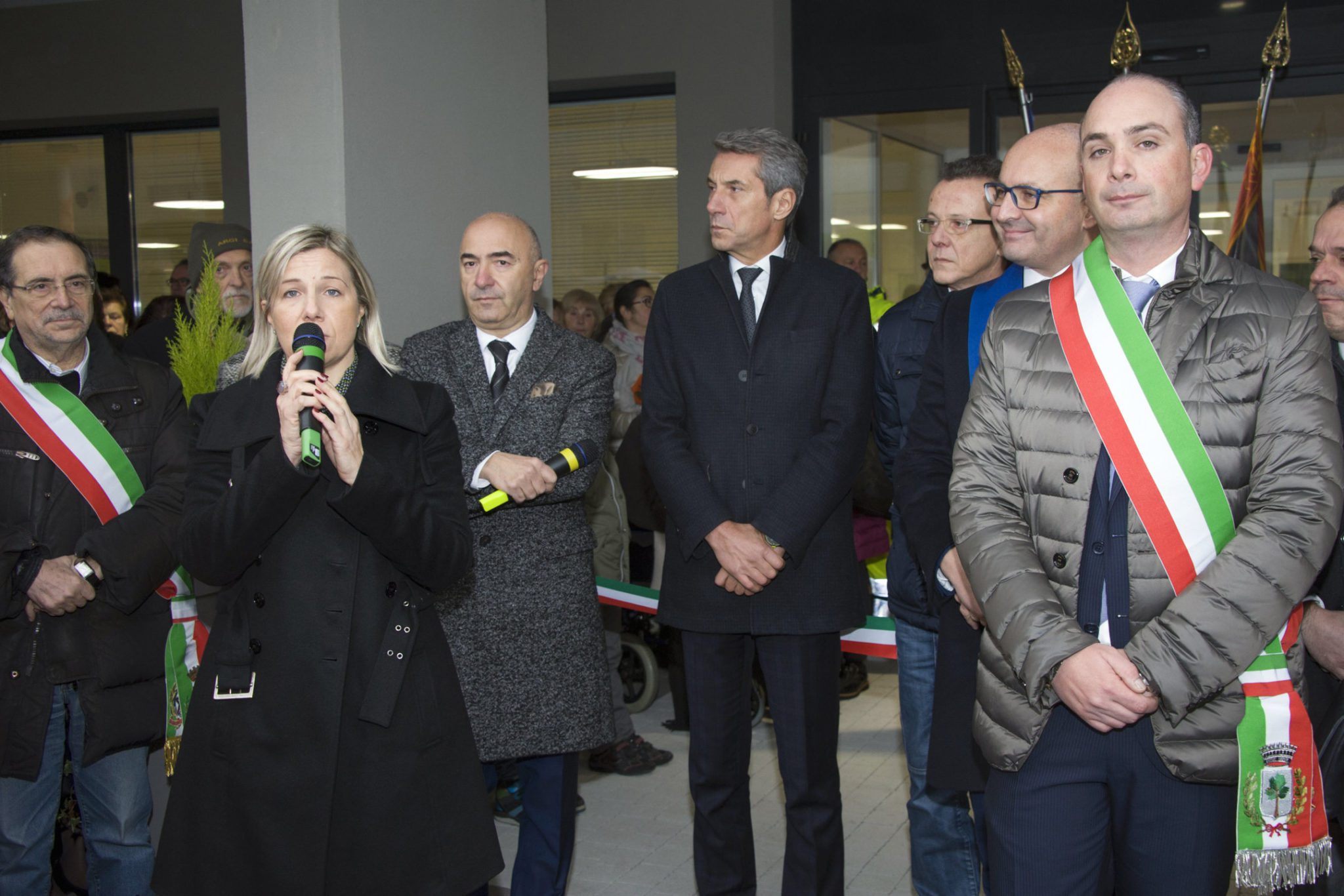Un'immagine che ritrae pantaloni, capispalla, in piedi, gruppo sociale e cappotto.