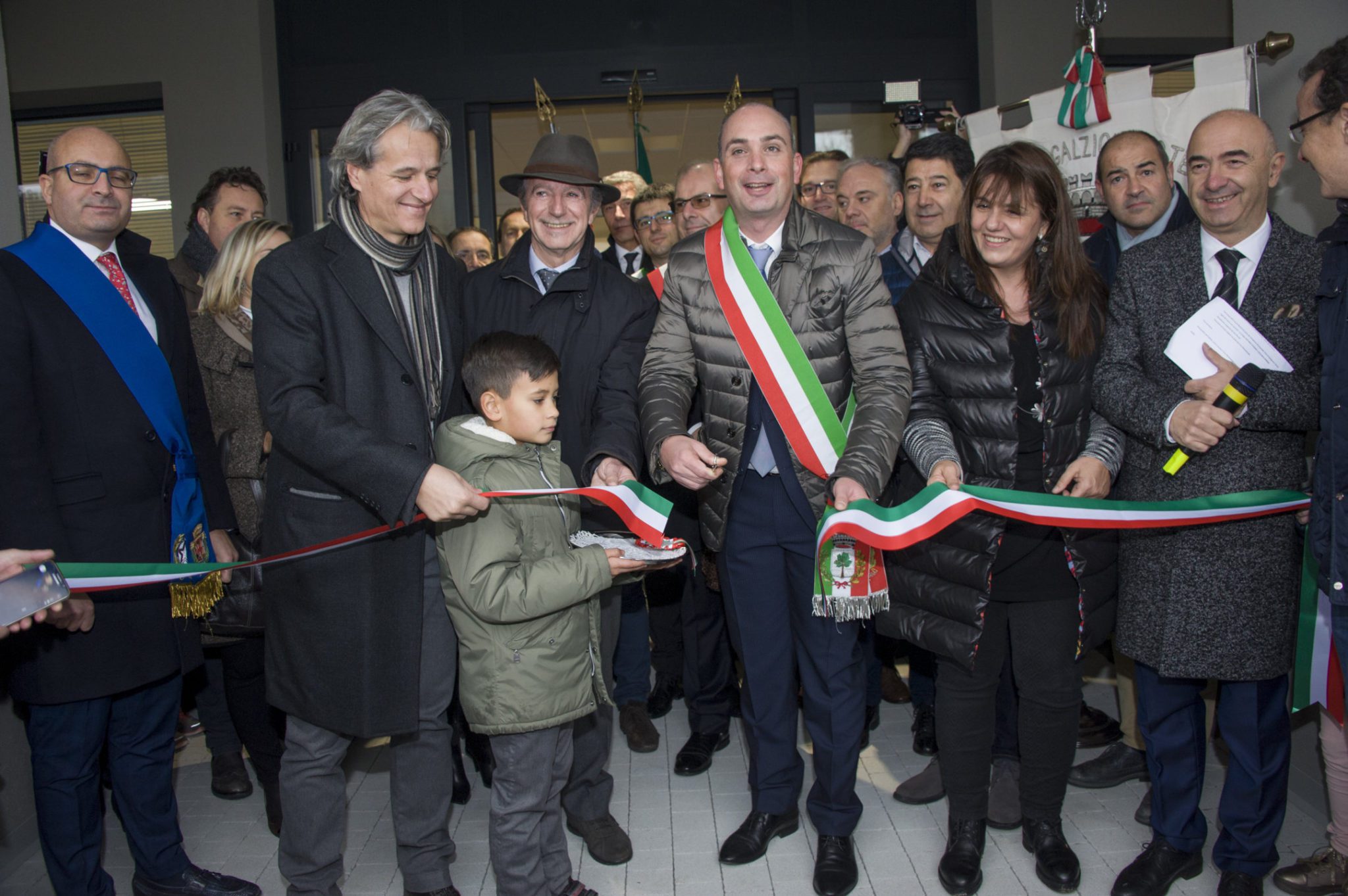 Un'immagine che ritrae pantaloni, capispalla, gruppo sociale, in piedi e sorriso.