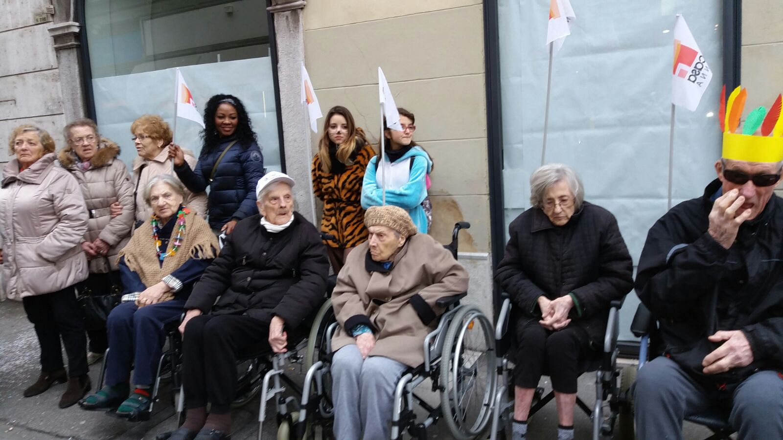 Un'immagine che ritrae persone, sedia a rotelle, pantaloni, capispalla e scarpa.