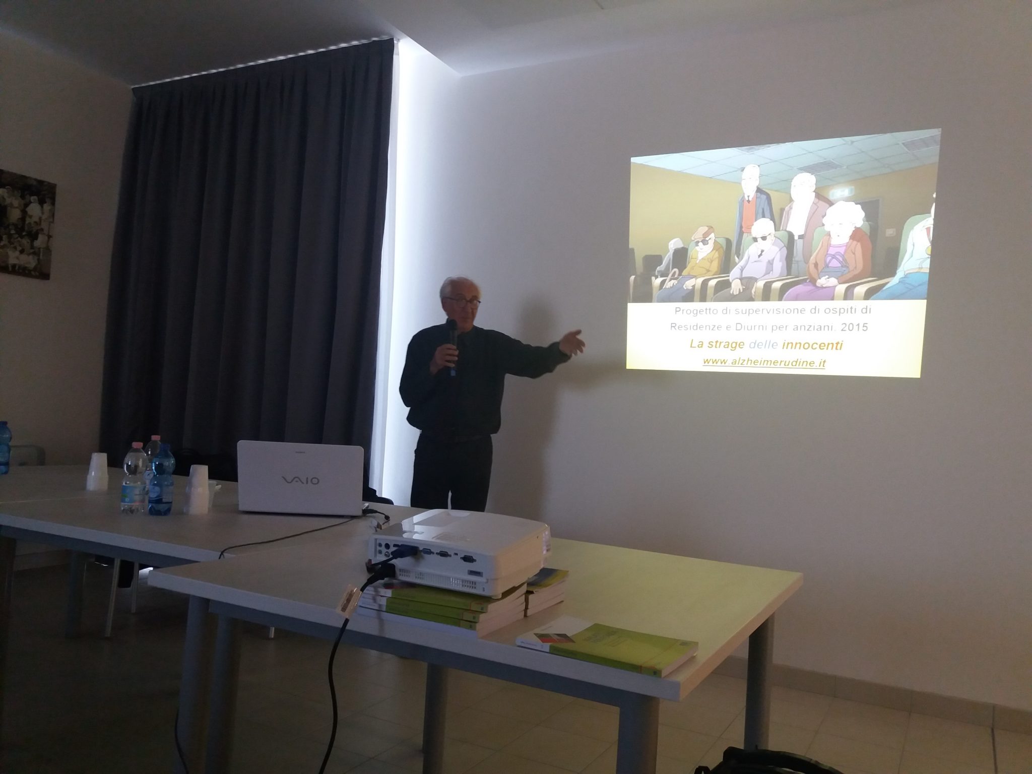 Un'immagine che ritrae dispositivo elettronico, mobilia, presentazione, tavolo e dispositivo di visualizzazione.