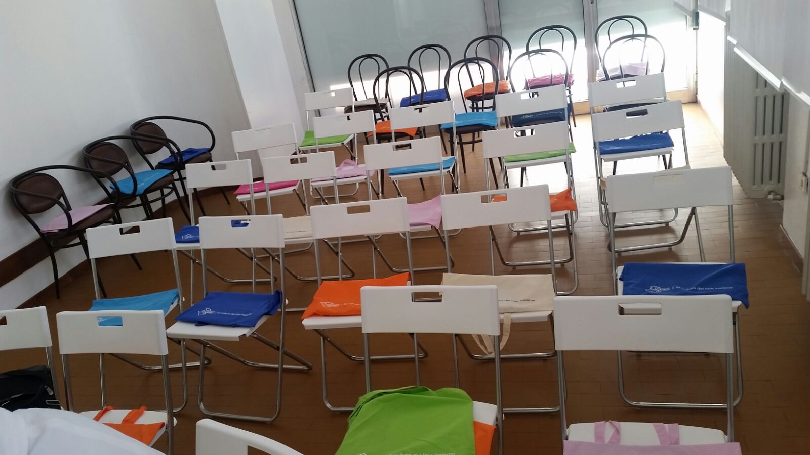 Un'immagine che ritrae mobilia, pavimento, pavimentazione, sedia e sedia pieghevole.