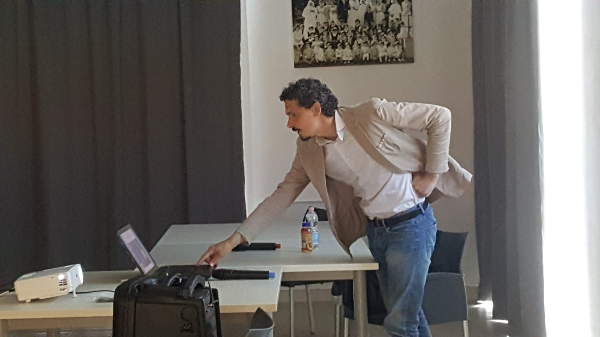 Un'immagine che ritrae pantaloni, mobilia, pavimento, dispositivo elettronico e impiegato.