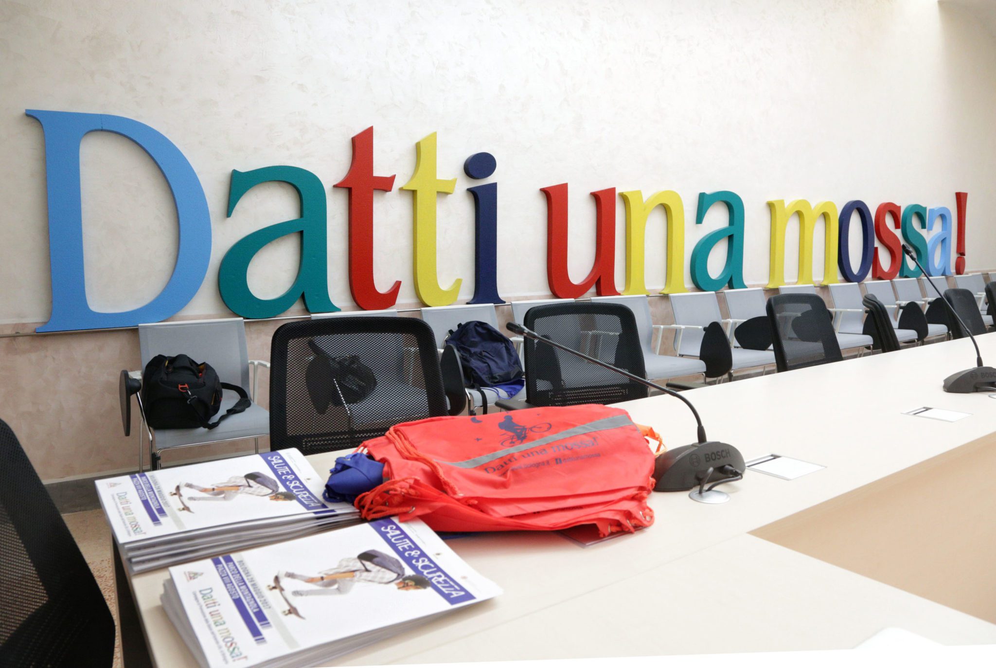 Un'immagine che ritrae logo, sedia, azienda, pubblicità e organizzazione.