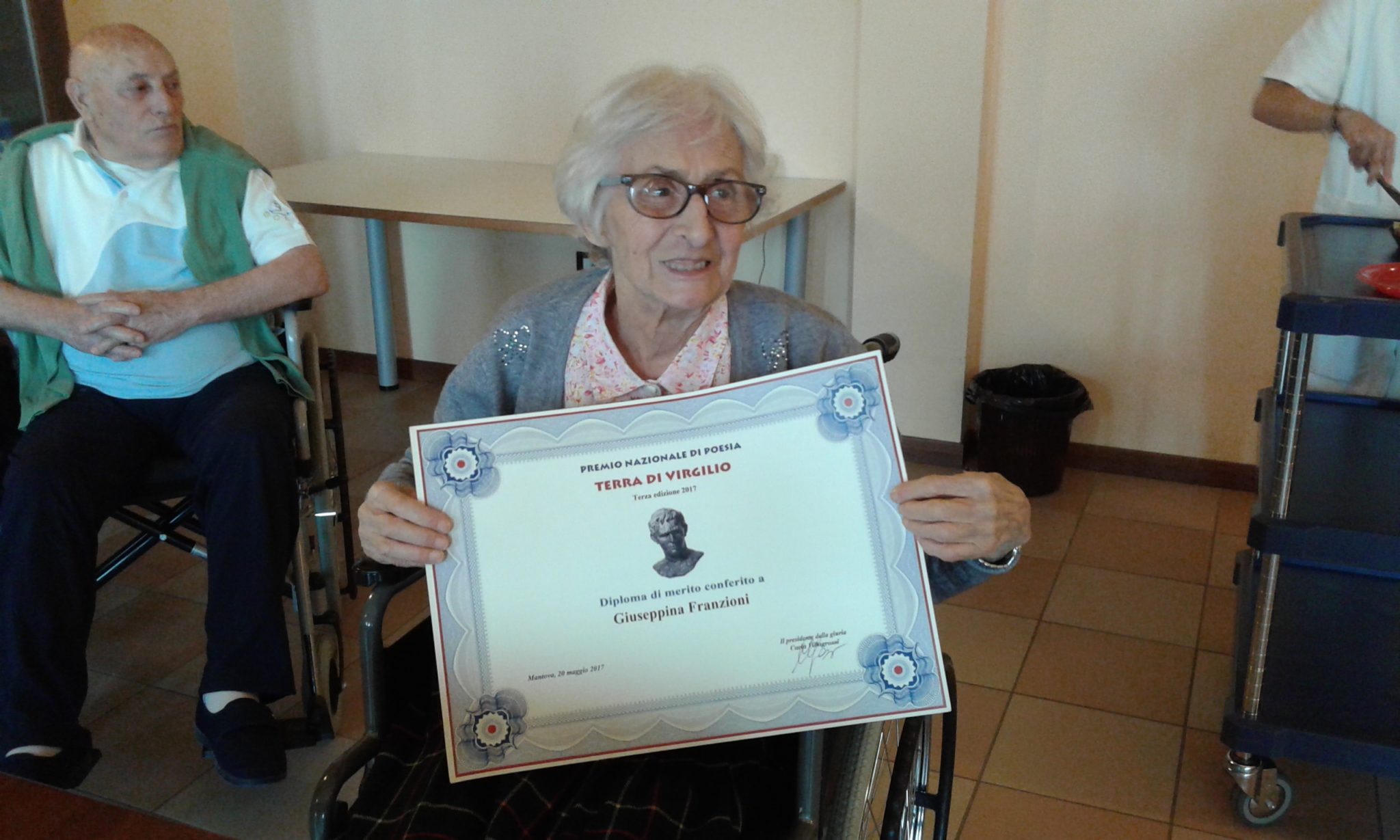 Un'immagine che ritrae sedia, cornice, premio e cerimonia di premiazione.