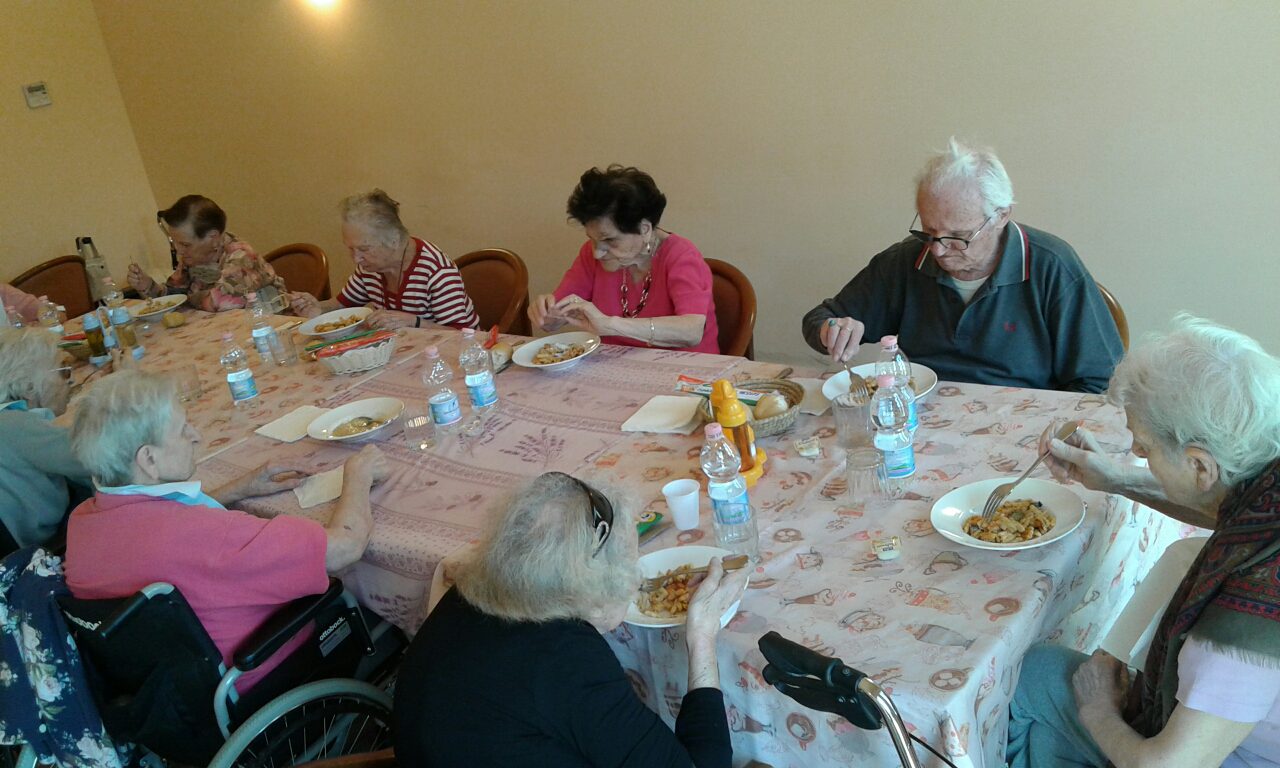 Un'immagine che ritrae mobilia, tavolo, stoviglie, sedia e comunità.