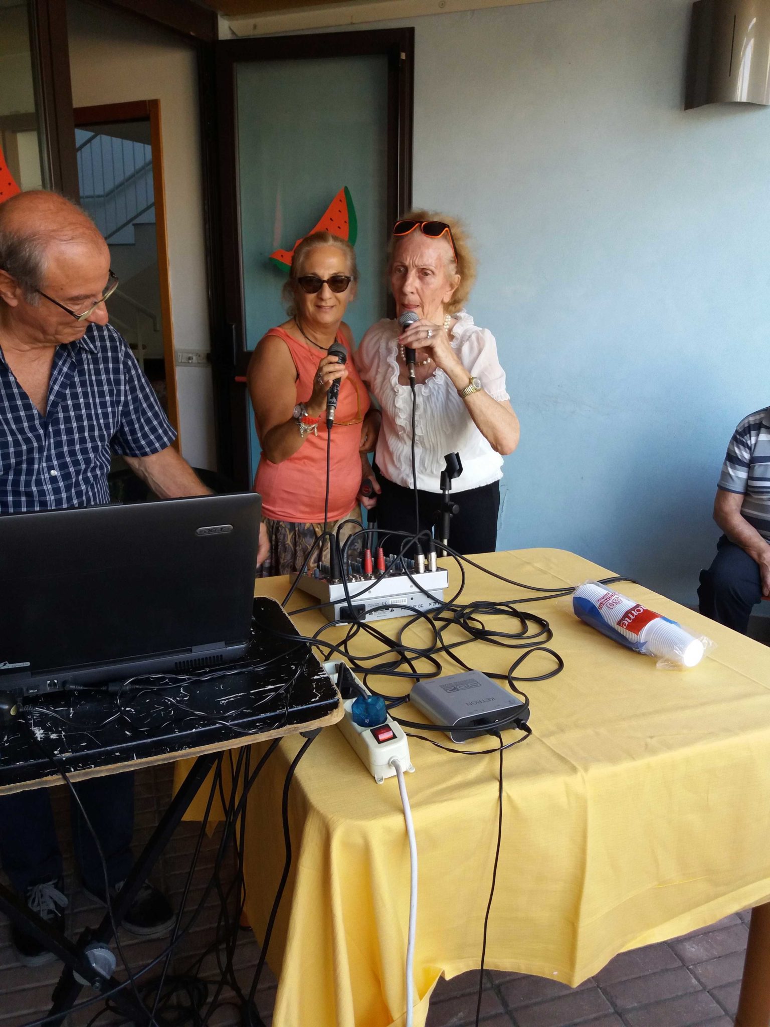 Un'immagine che ritrae dispositivo elettronico, mobilia, braccio, camicia e tavolo.