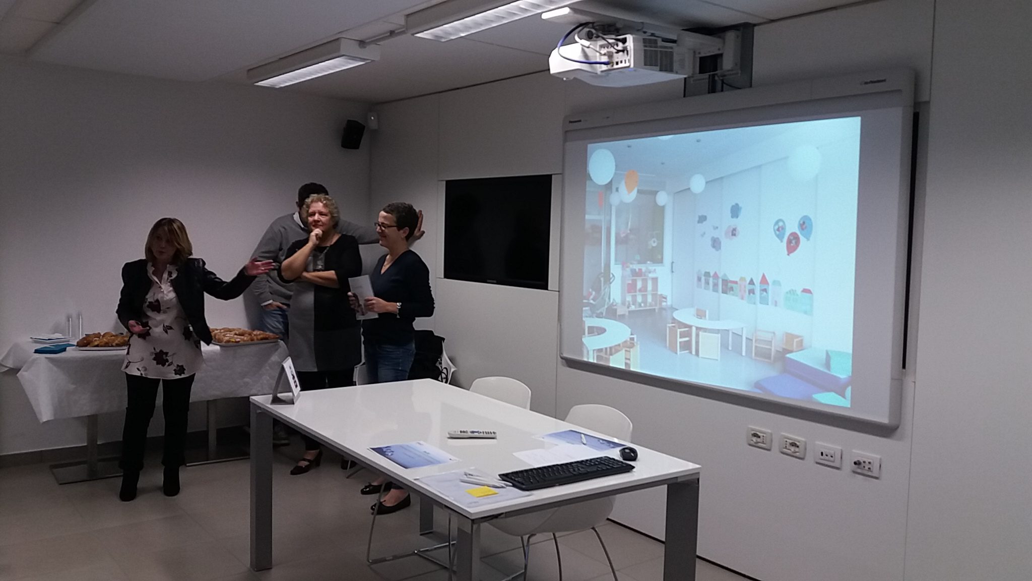 Un'immagine che ritrae dispositivo elettronico, mobilia, dispositivo di visualizzazione, videoproiettore e design d'interni.