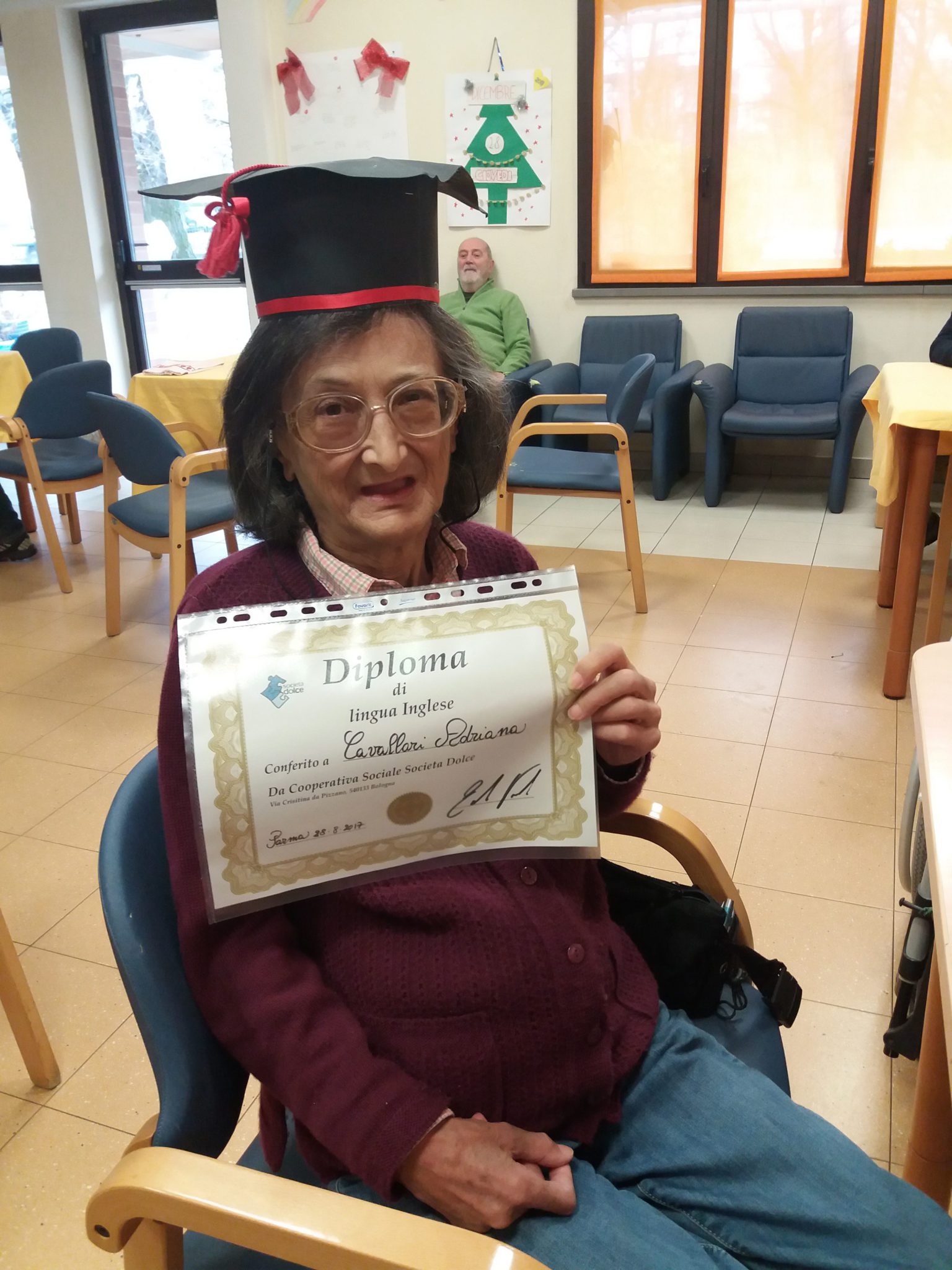 Un'immagine che ritrae sorriso, studioso, cappello accademico quadrato, abito accademico e cornice.