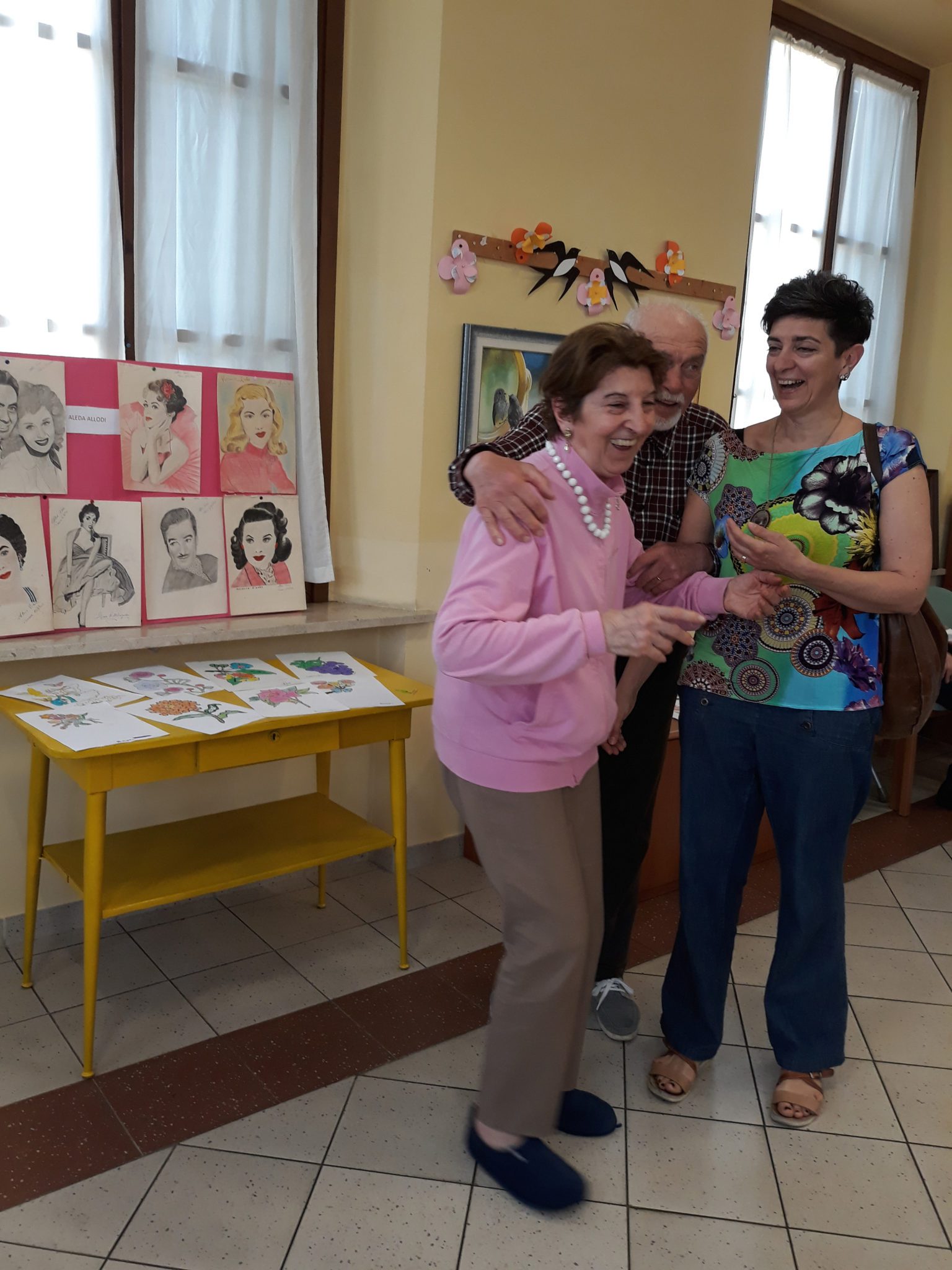 Un'immagine che ritrae braccio, mobilia, sorriso, camera e sedia.