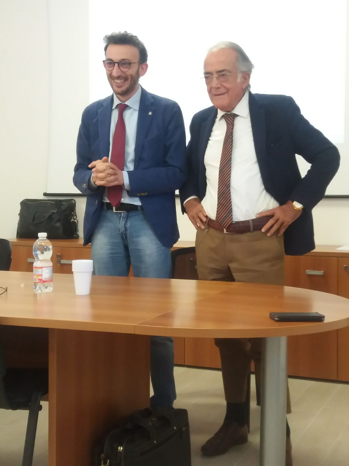 Un'immagine che ritrae mobilia, abbigliamento formale, impiegato, tavolo e blazer.