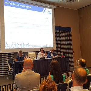 Un'immagine che ritrae mobilia, dispositivo elettronico, evento, presentazione e sedia.