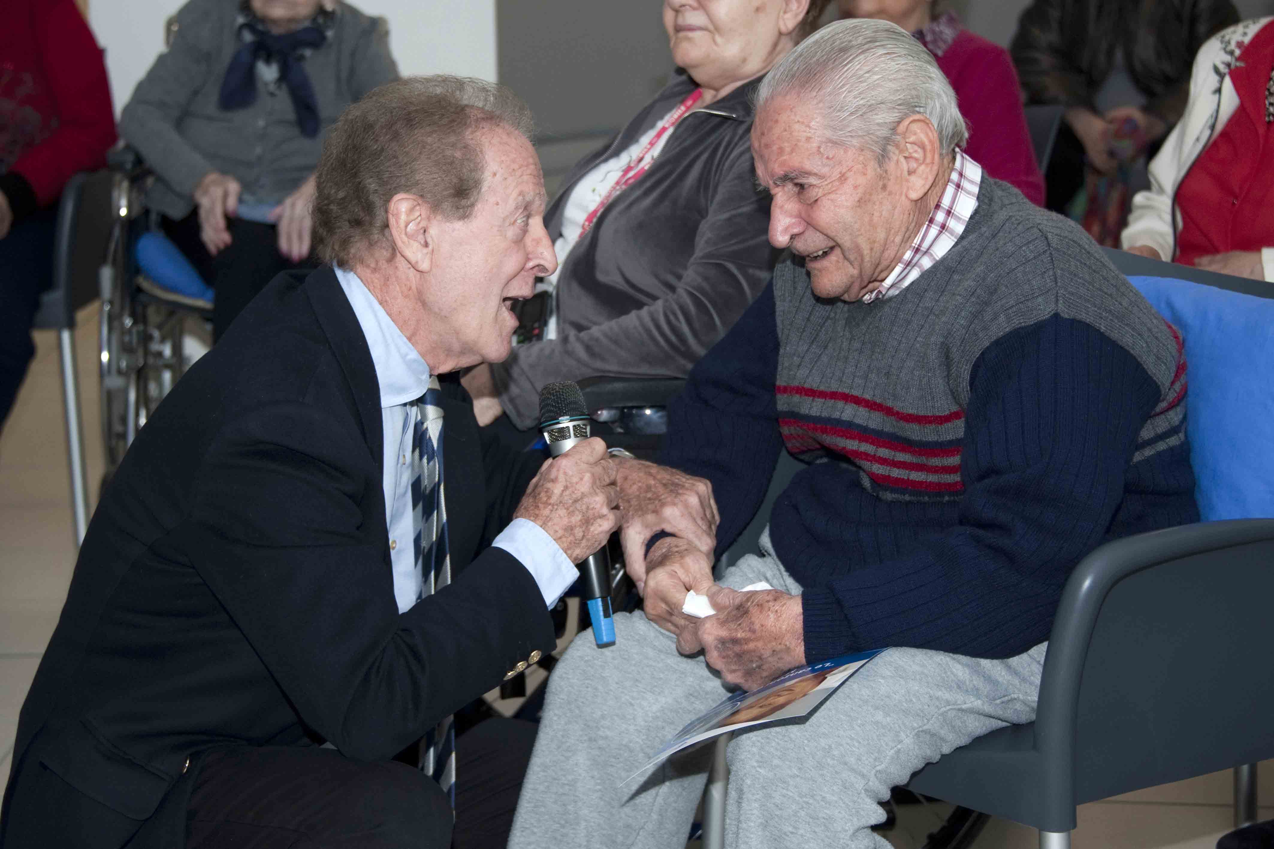 Un'immagine che ritrae capispalla, cappotto, seduta, interazione e abito.