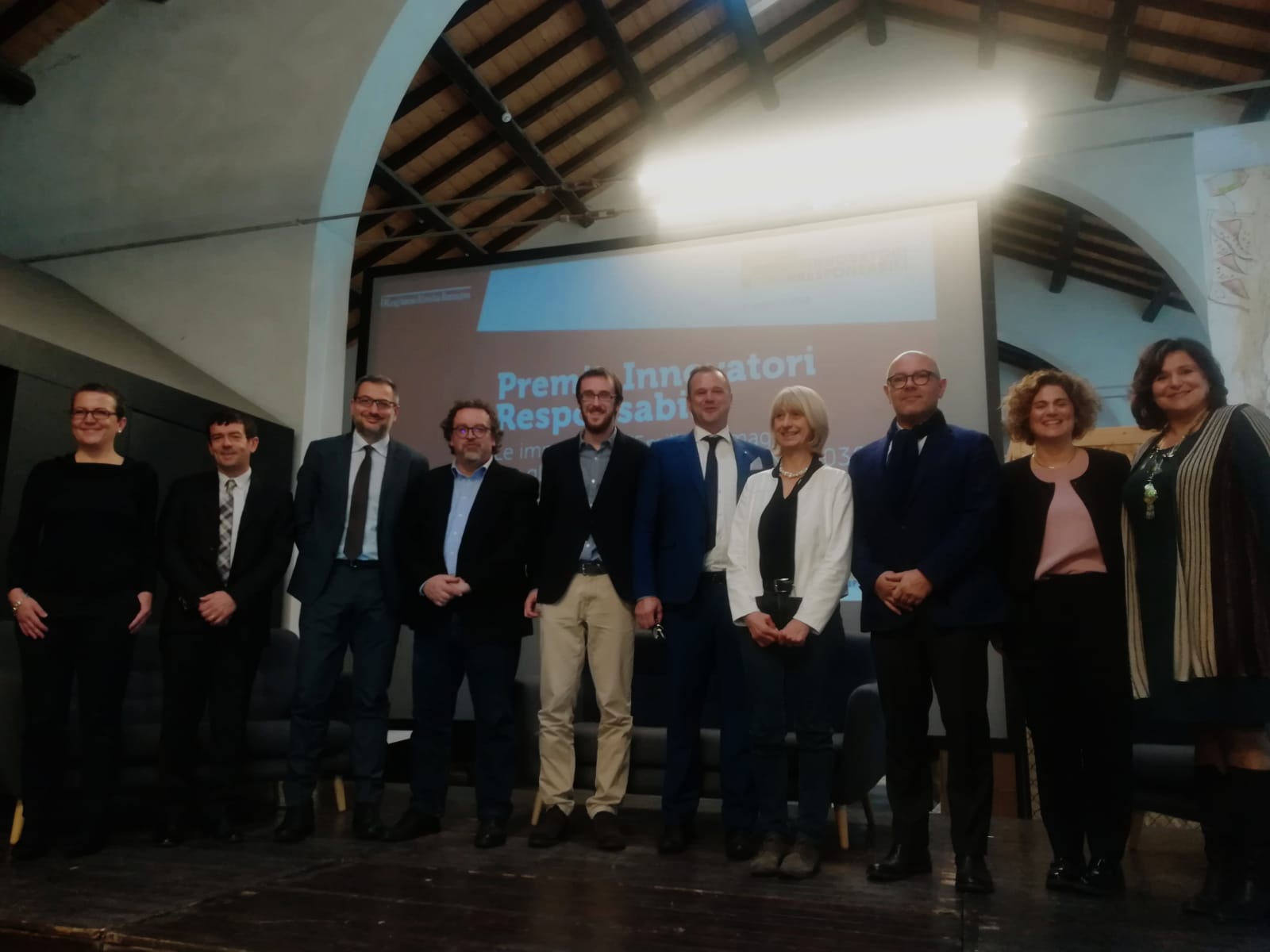 Un'immagine che ritrae sorriso, cappotto, impiegato, abito e pantaloni da abito.