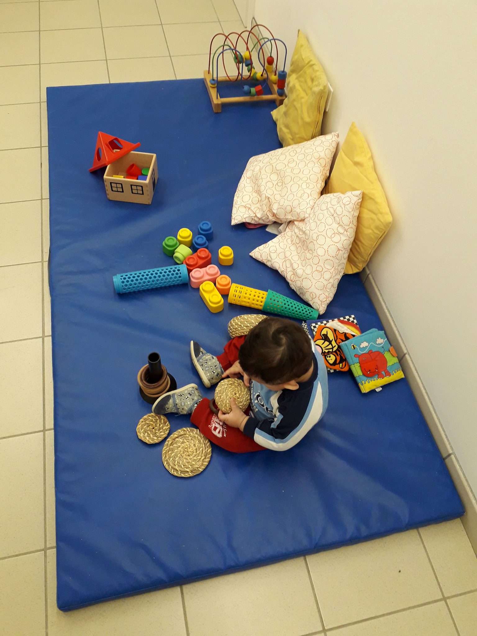 Un'immagine che ritrae pavimentazione, pavimento, bambino, giocattoli per bambini e stuoia.