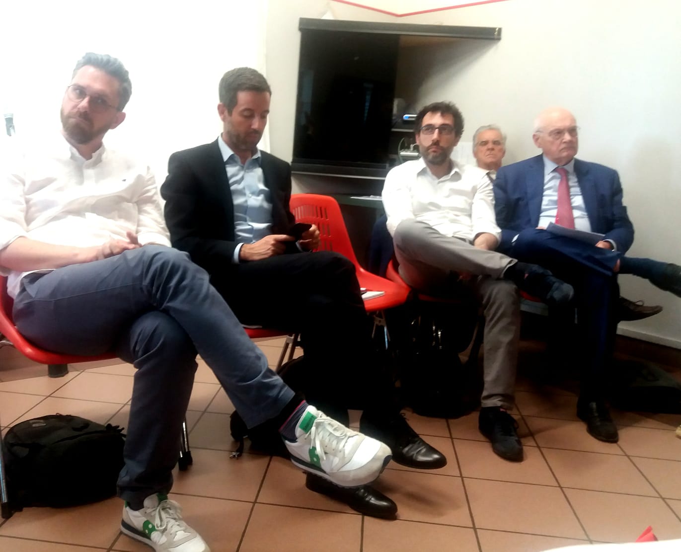 Un'immagine che ritrae mobilia, pantaloni, scarpa, seduta e gamba.