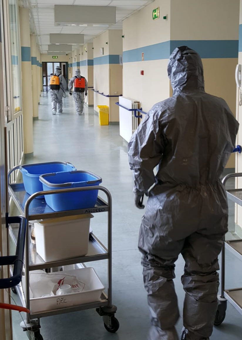 Un'immagine che ritrae abbigliamento da lavoro, dispositivi di protezione individuale, uniforme, pavimento e tuta anti-contaminazione.