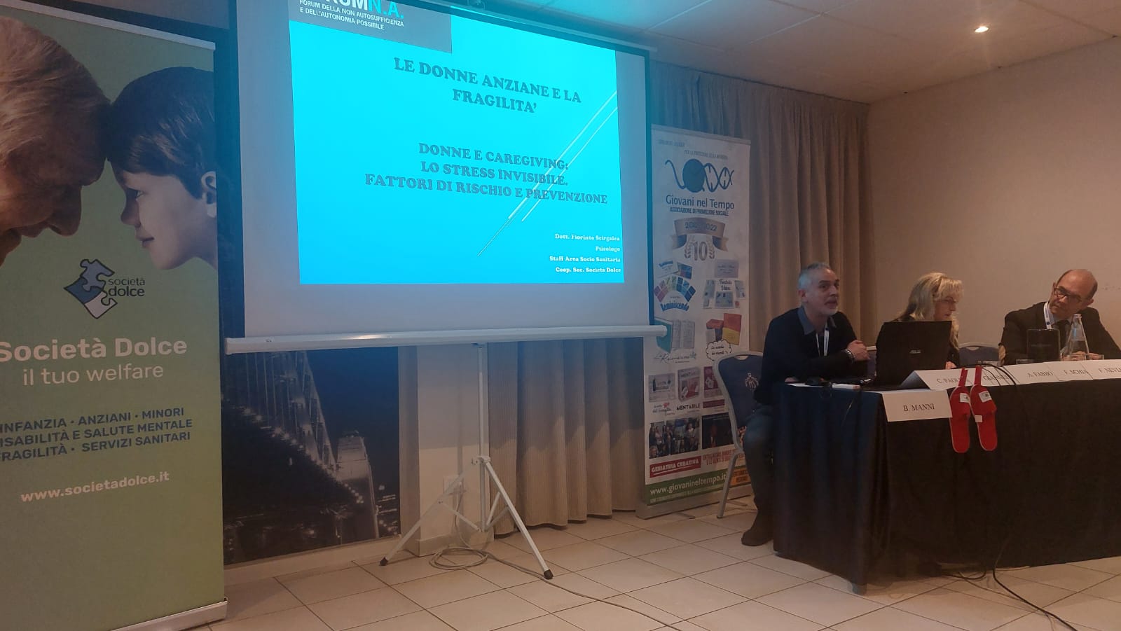 Un'immagine che ritrae dispositivo elettronico, evento, presentazione, dispositivo di visualizzazione e mobilia.