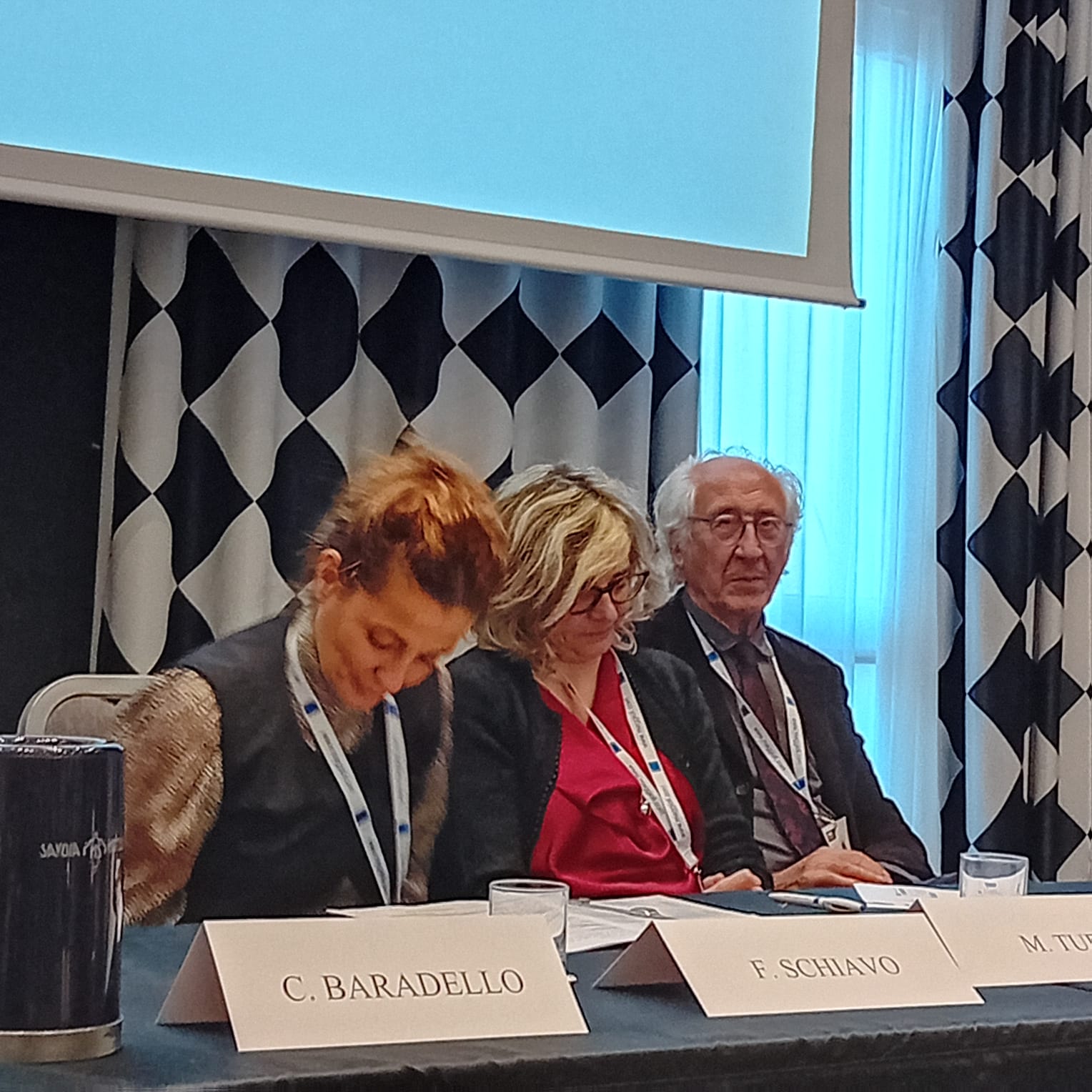 Un'immagine che ritrae mobilia, cappotto, sedia, conversazione e lavoro.