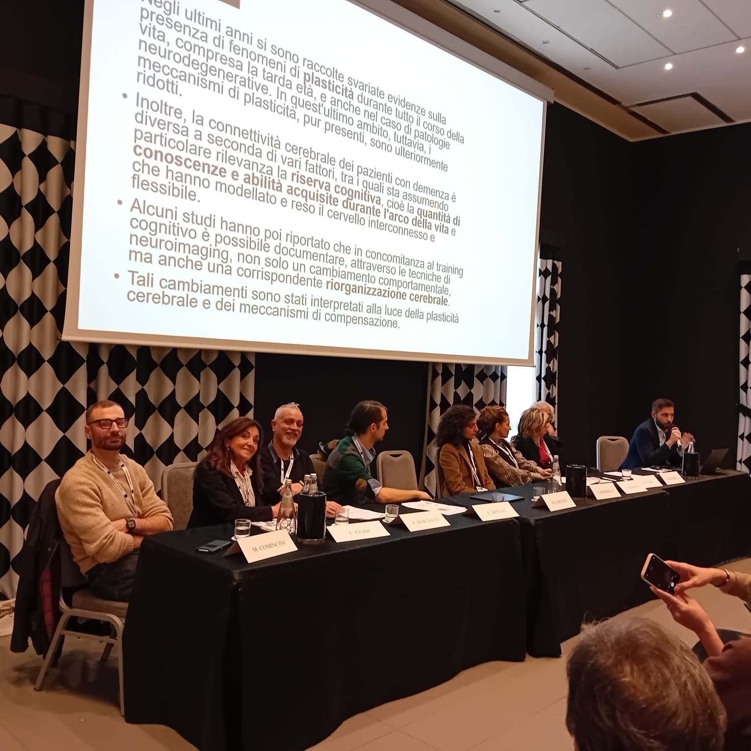 Un'immagine che ritrae mobilia, evento, abito, cappotto e sedia.