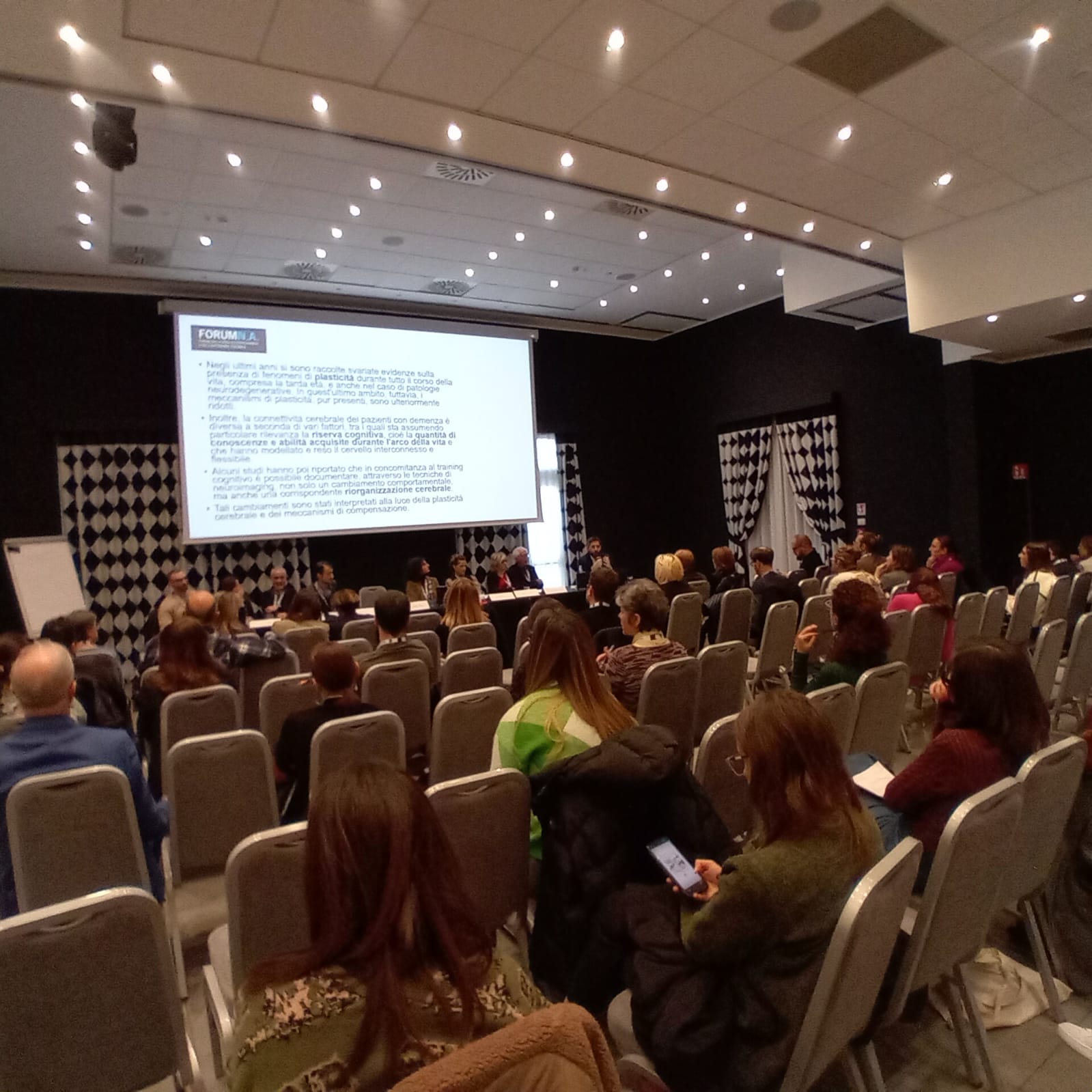 Un'immagine che ritrae mobilia, sedia, evento, sala e pubblico.